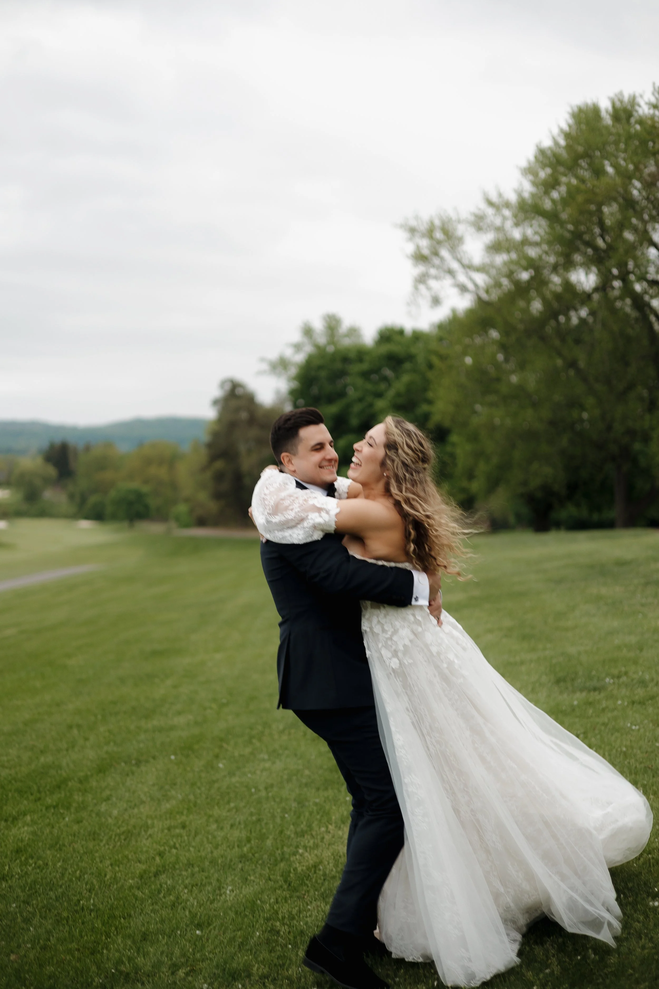 Groom spinning the bride and laughing during their Dundas Valley Golf Course wedding in Ontario, photographed by James and Alyson Photo