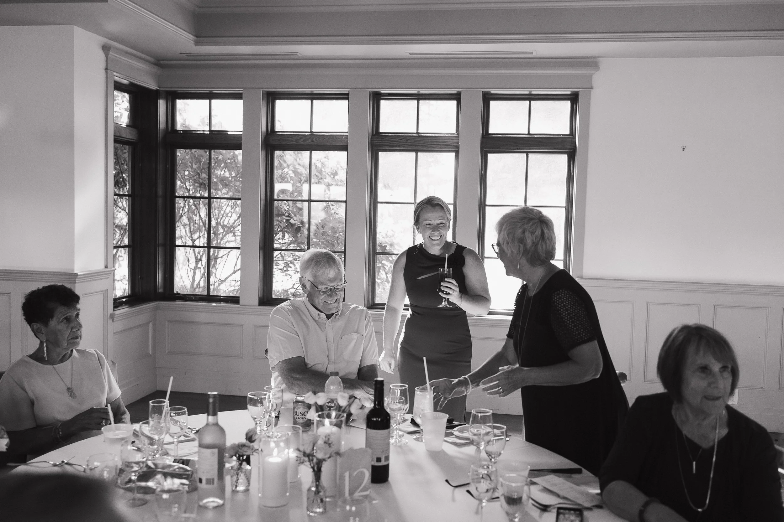 guests laughing together at reception, Ontario wedding photography by James and Alyson Photography