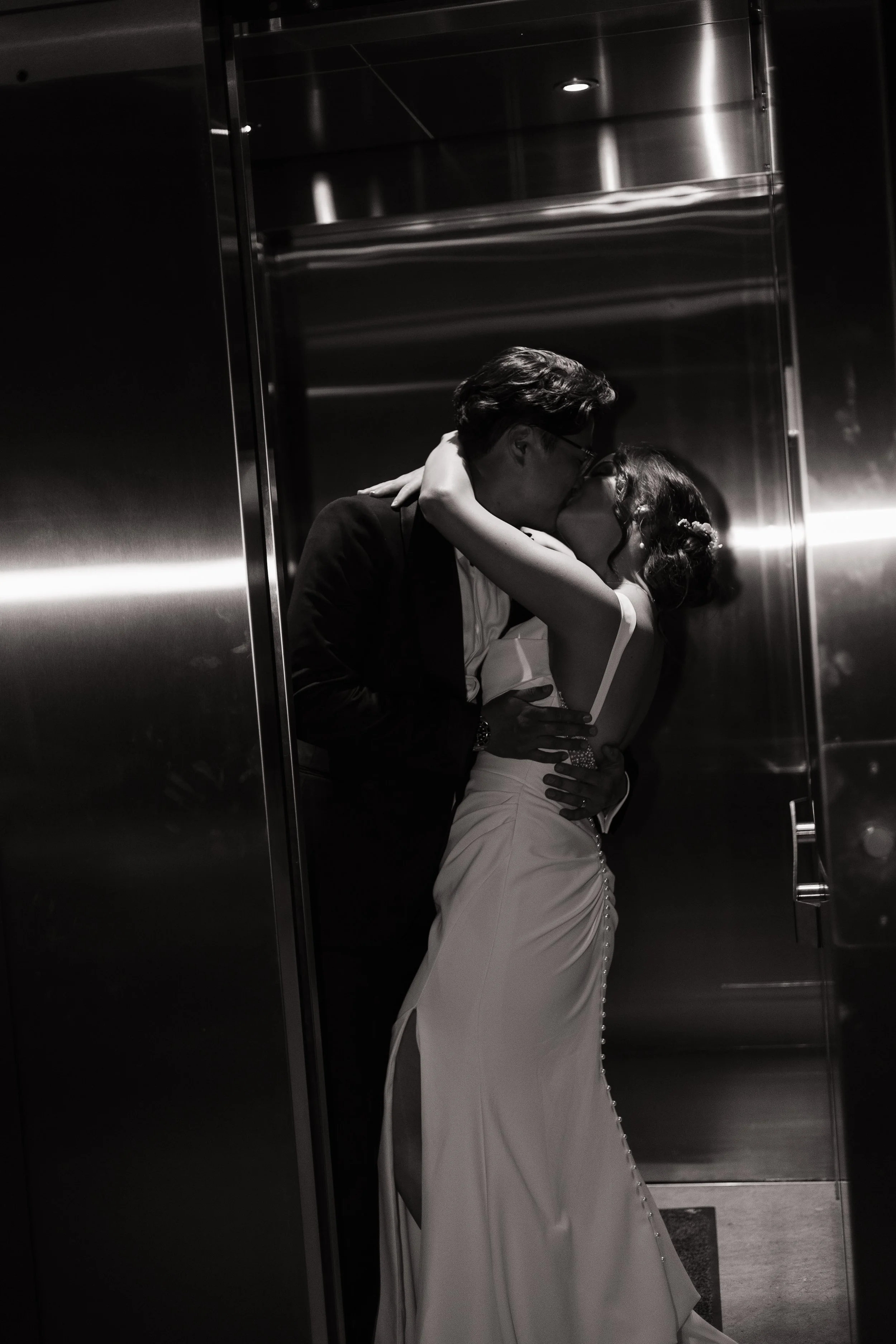 Bride and groom kissing in the elevator, Tapestry Hall Cambridge wedding, Ontario wedding photography by James and Alyson Photography