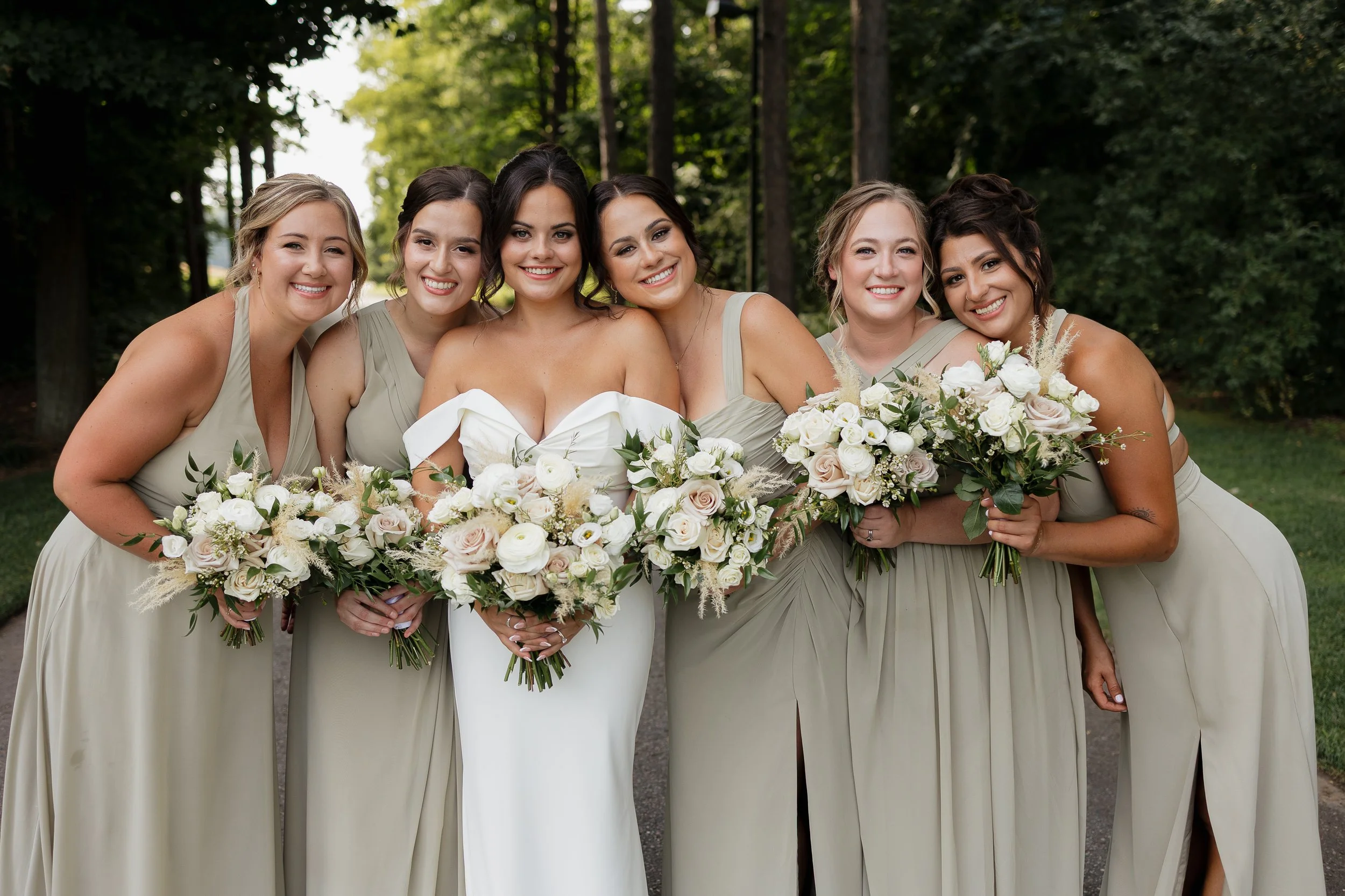 Bridal party smiling and hugging the bride, Ontario wedding photography by James and Alyson Photography