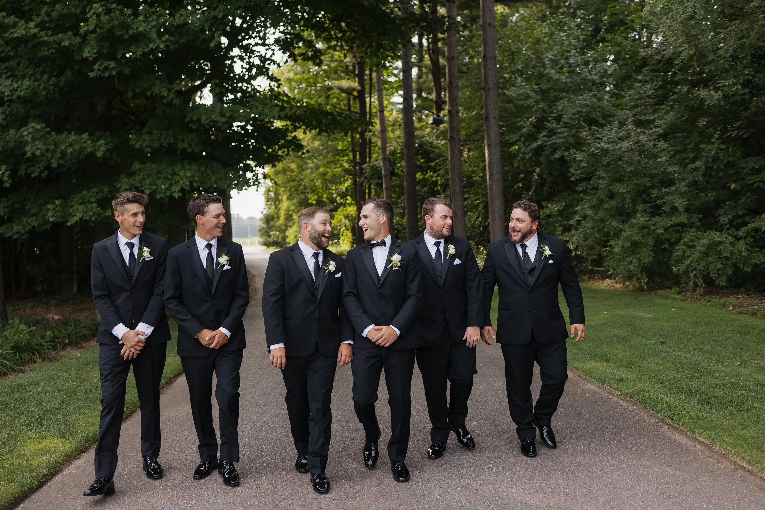 groom and groomsmen laughing and walking towards the camera, Ontario wedding photography by James and Alyson Photography