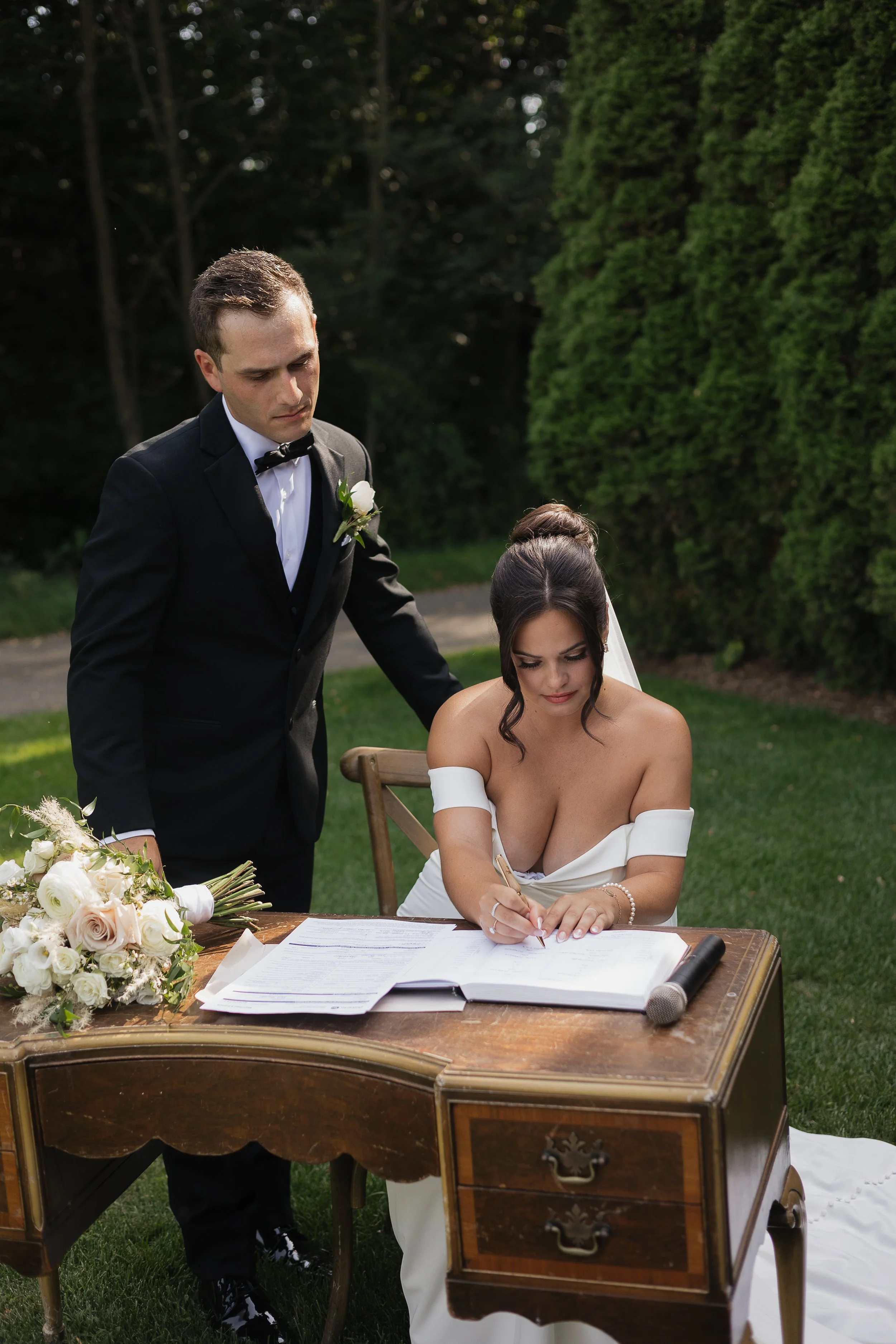 bride signing the wedding certificate during the ceremony, Ontario wedding photography by James and Alyson Photography