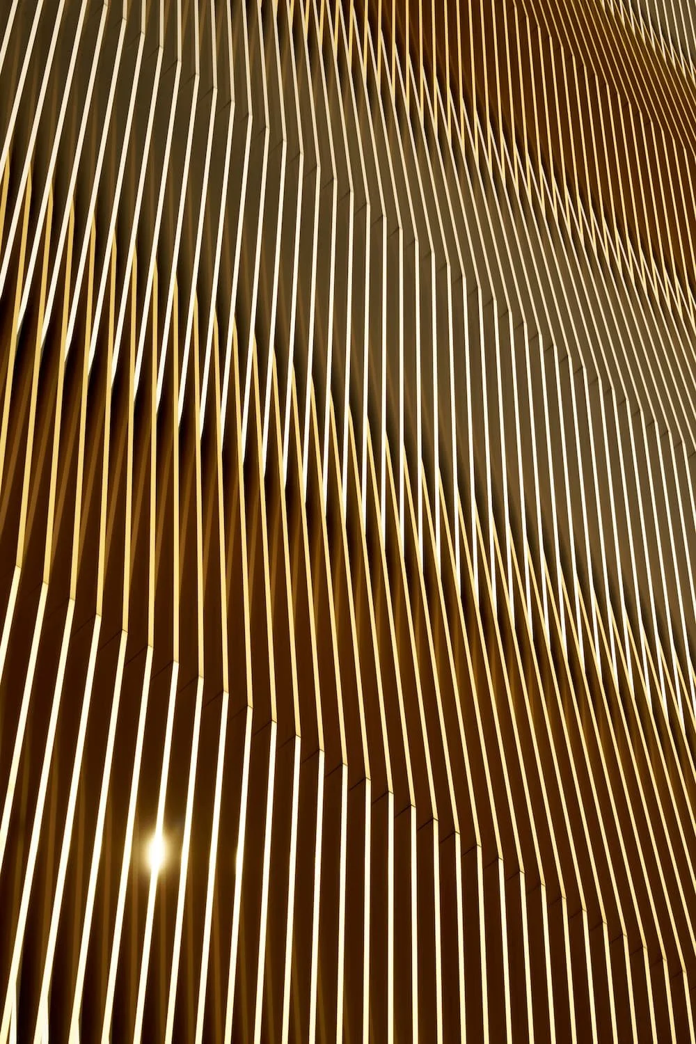 Close-up view of an architectural structure with multiple vertical, gold-colored corrugated panels.