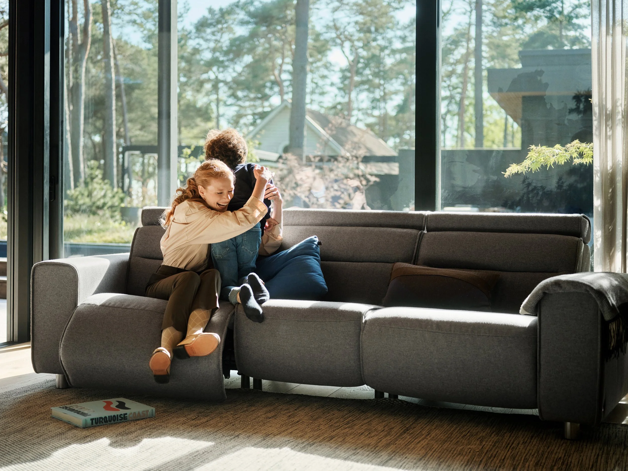 Adult and child hugging eah other on sofa, close interaction in living room