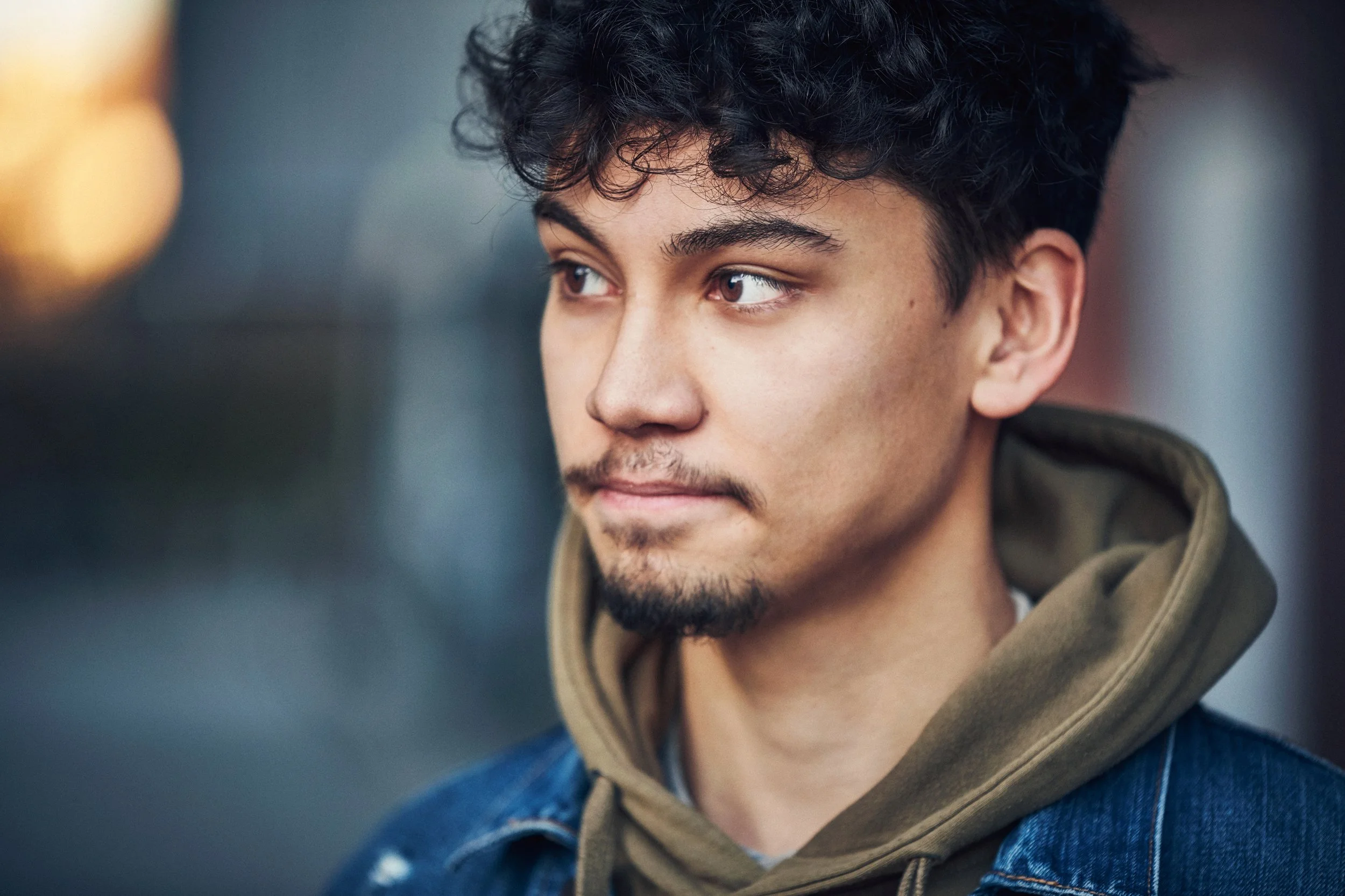 Portrait of young man outdoors, neutral expression in urban environment