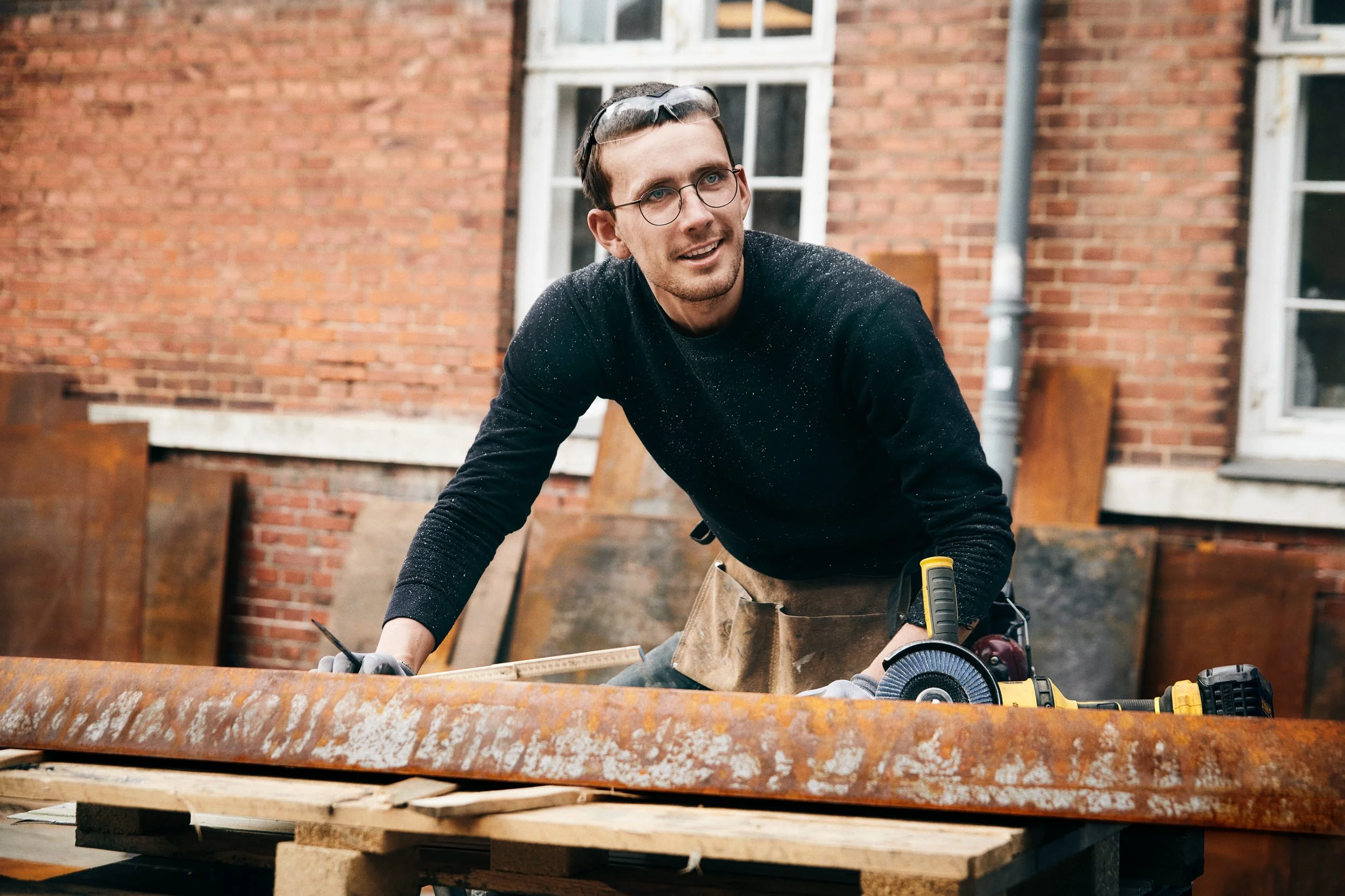 Man working with materials outdoors, hands-on task in craft environment
