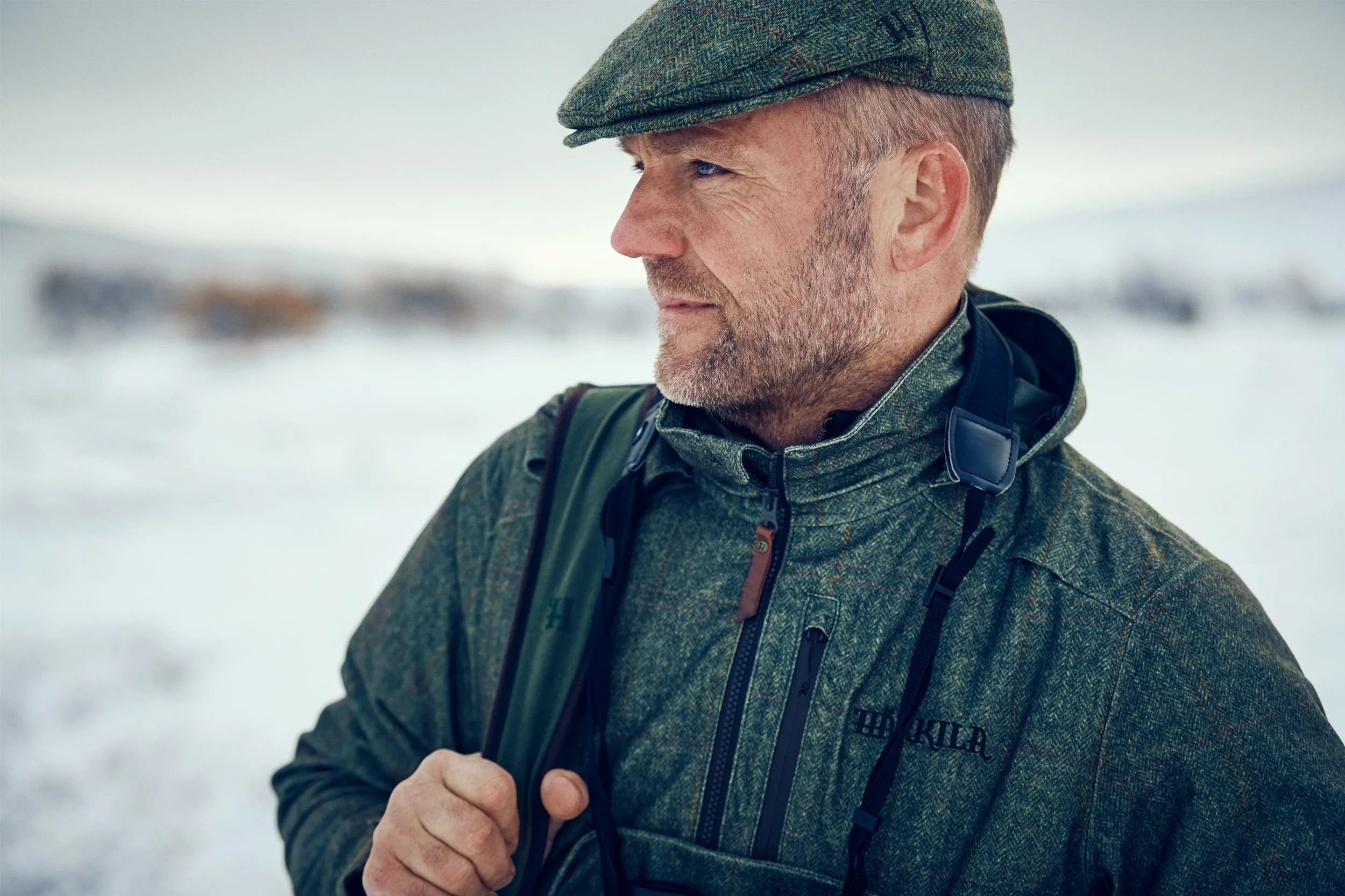 Portrait of hunter in cold conditions, layered clothing and wind visible