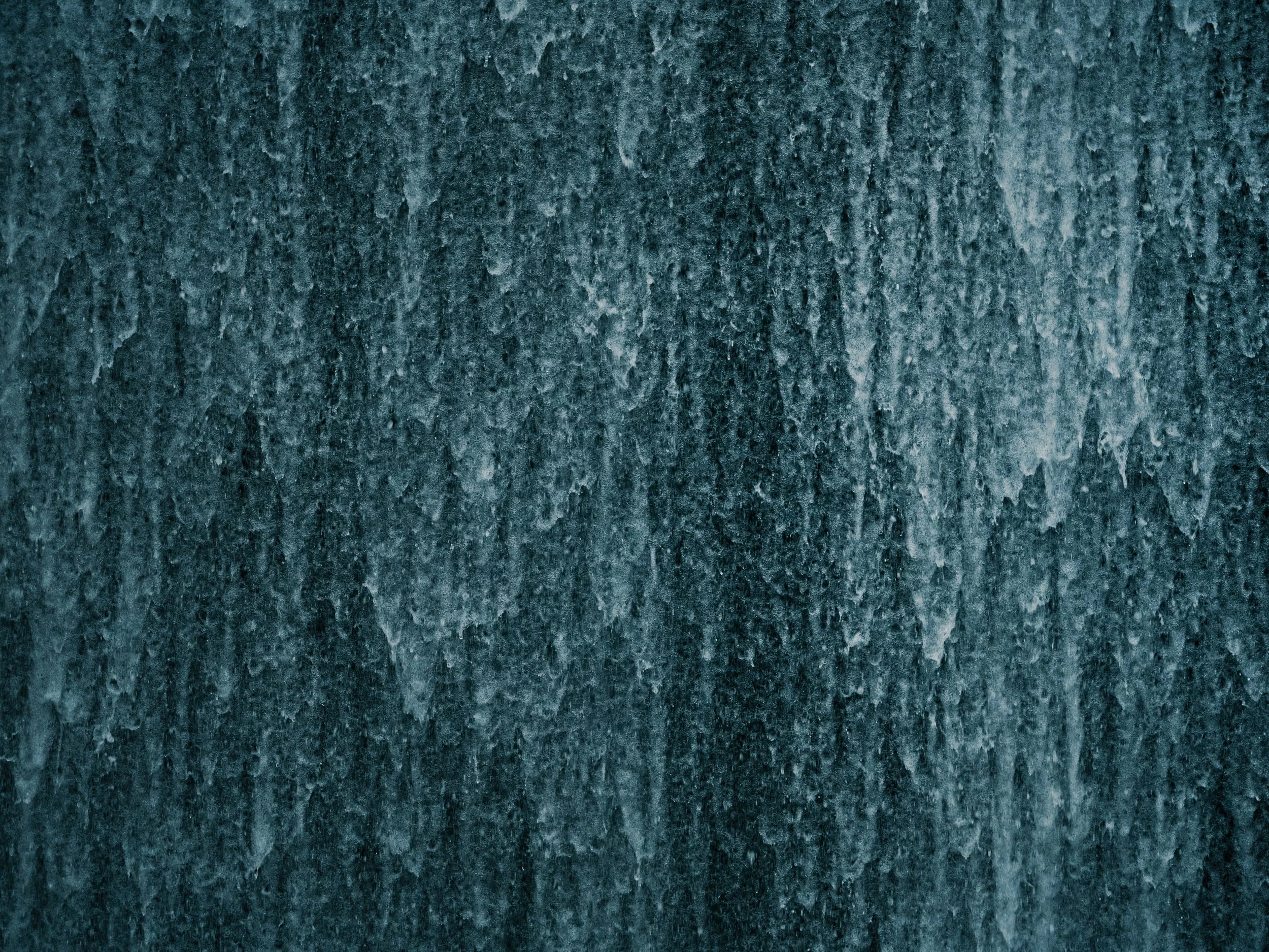 Close-up of water surface running down textured wall