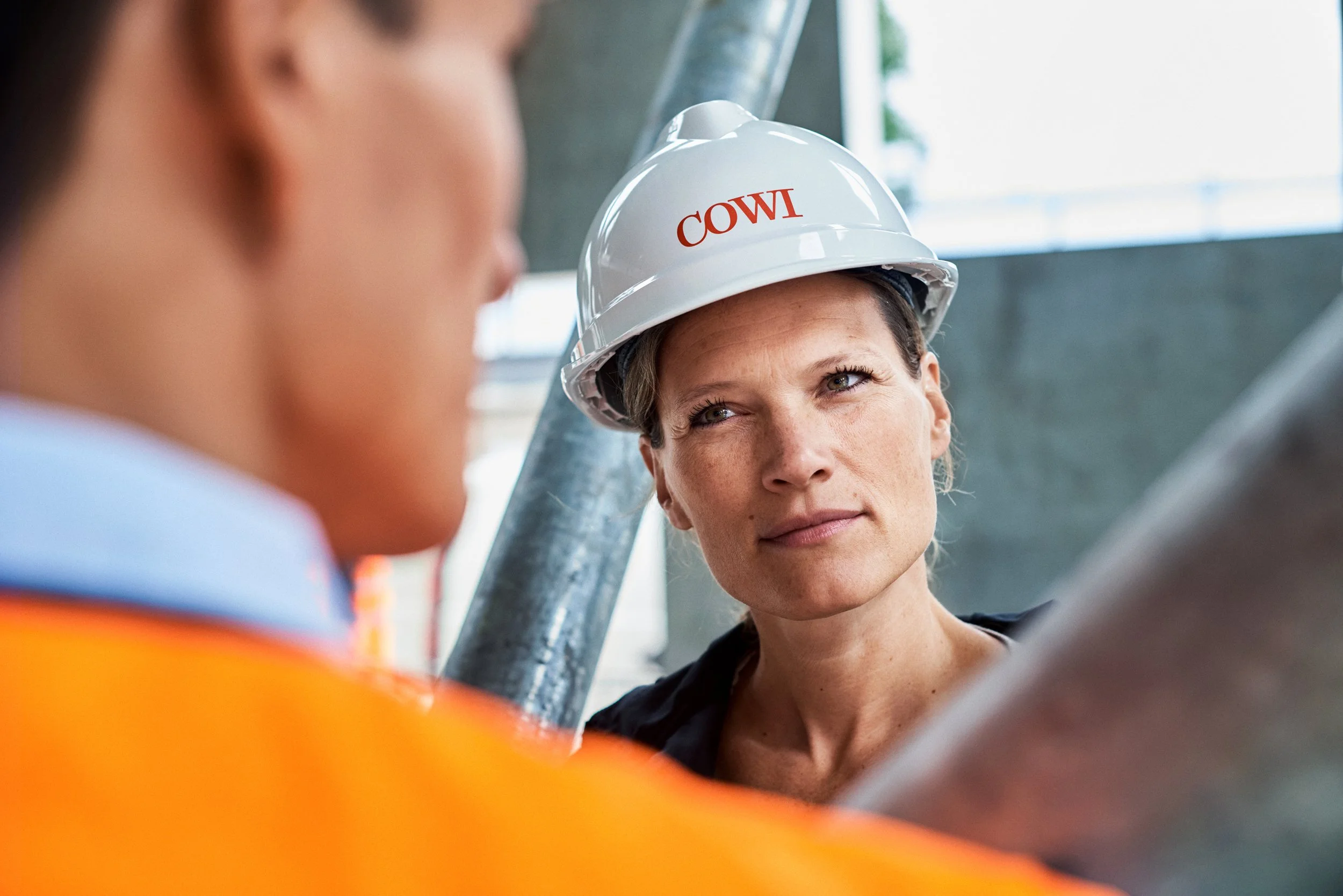 Engineer wearing helmet listening during site discussion