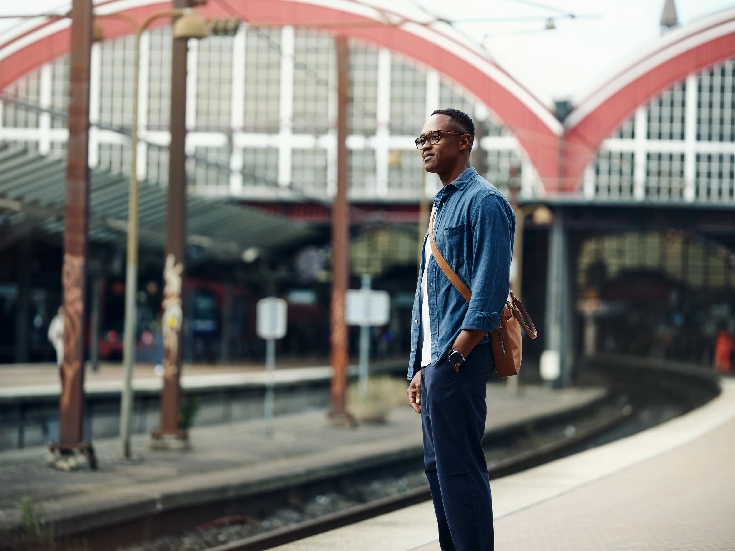 Man standing on train platform, waiting during daily commute