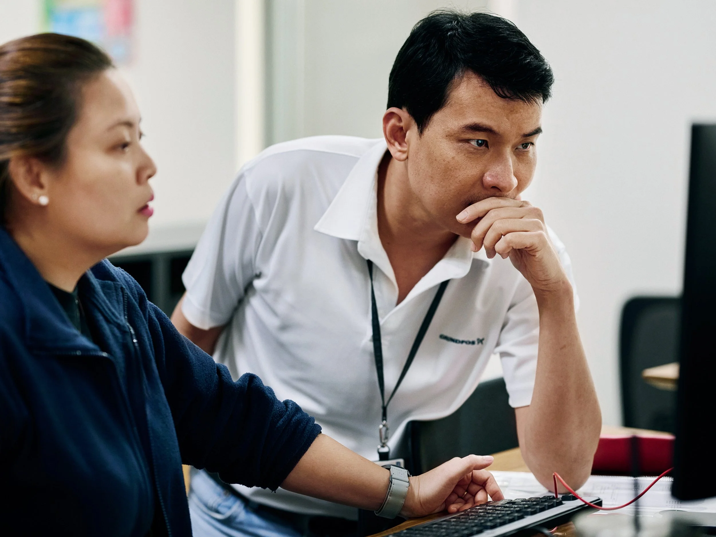 Engineers reviewing data on computer during development process, focused collaboration