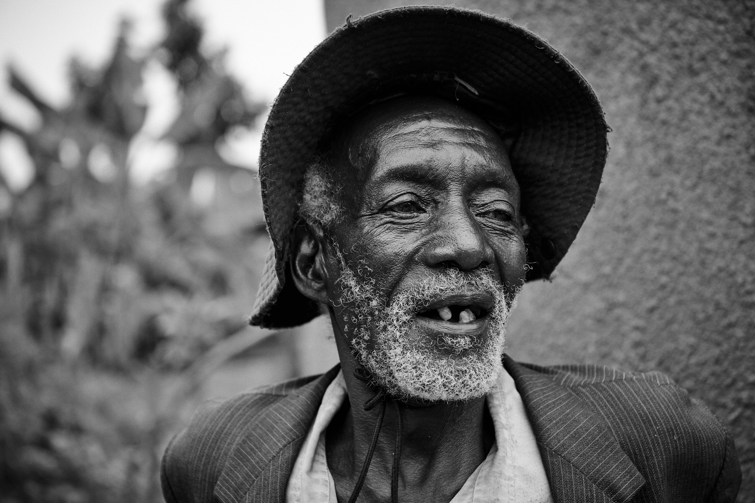 Portrait of older man wearing hat, relaxed expression in outdoor setting