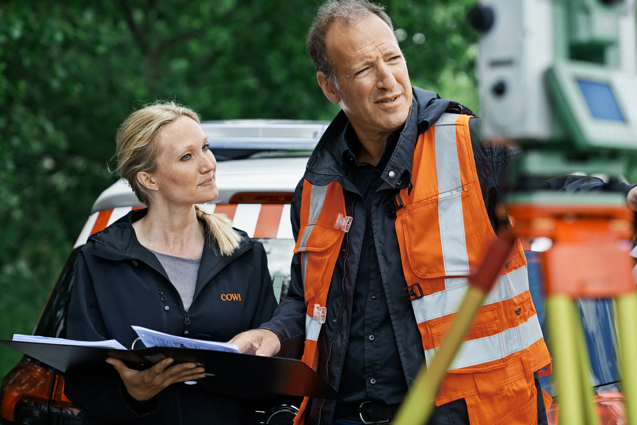 Engineers reviewing documents next to survey equipment