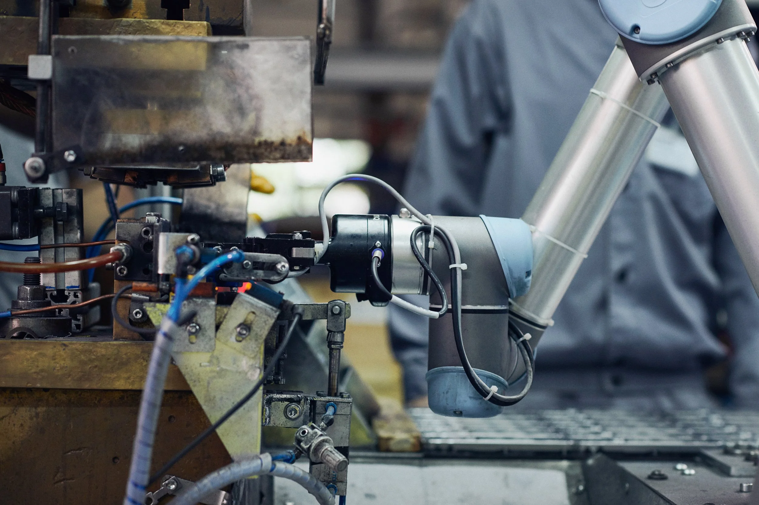 Close-up of collaborative robot integrated into industrial machine performing automated process 