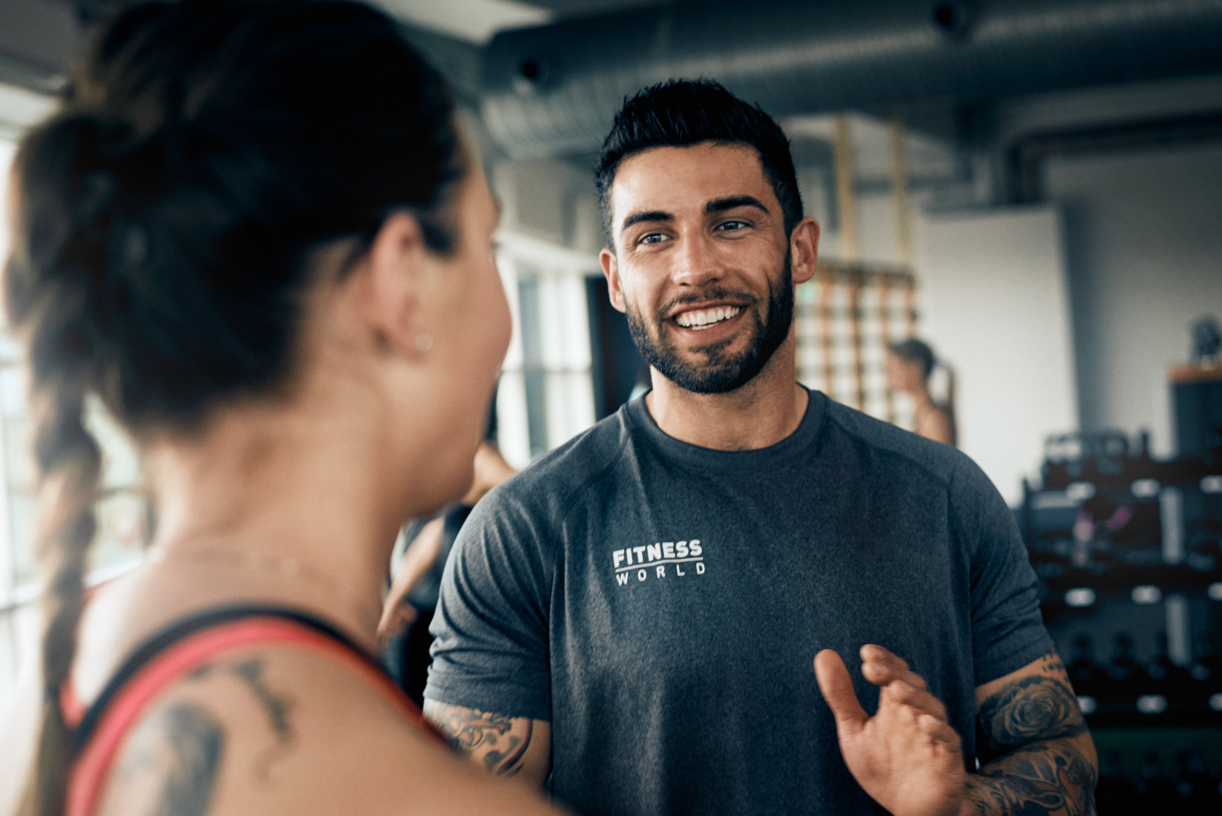 Trainer talking with member in gym, personal guidance and motivation