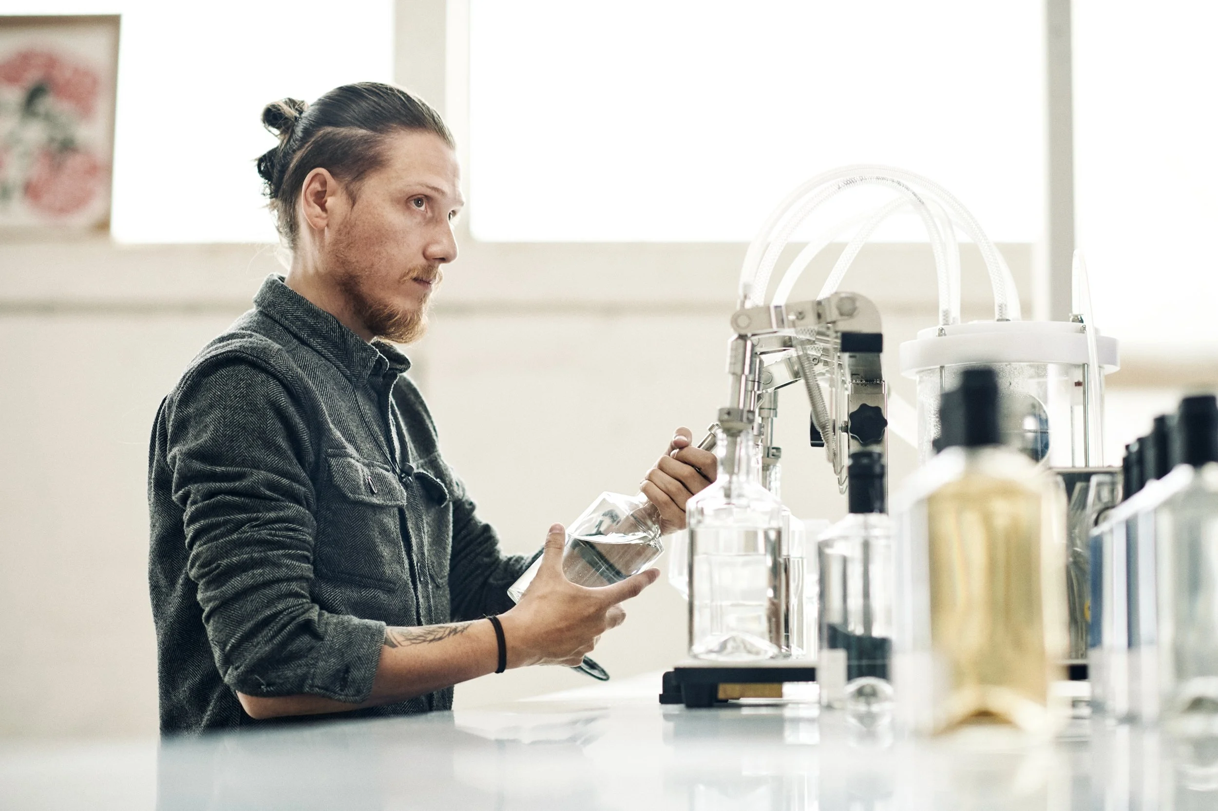 Distiller handling bottle at workstation, preparation and quality control
