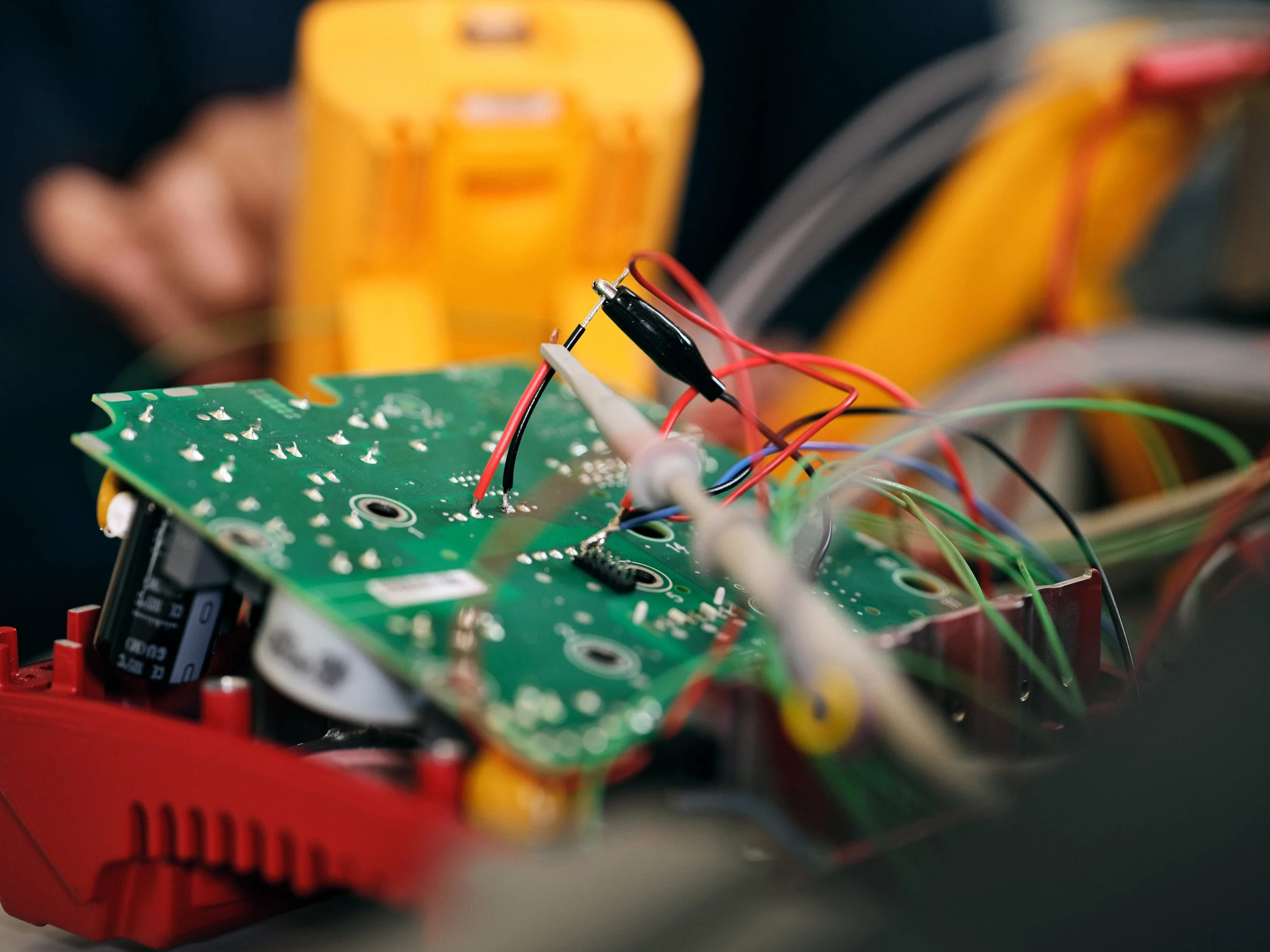 Close-up of circuit board with connected wires during electronics testing and development