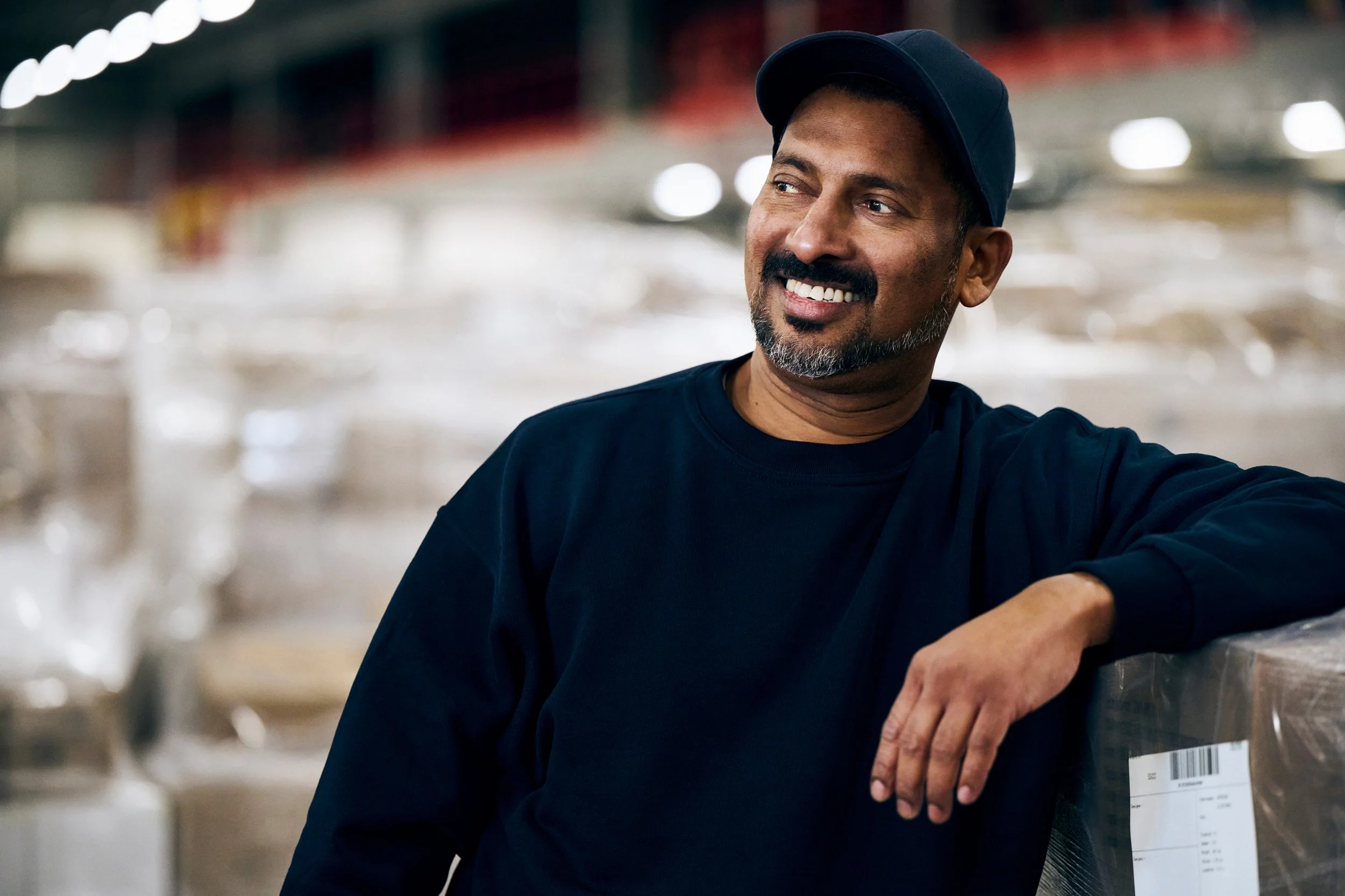 Man smiling in warehouse environment, casual portrait in work setting