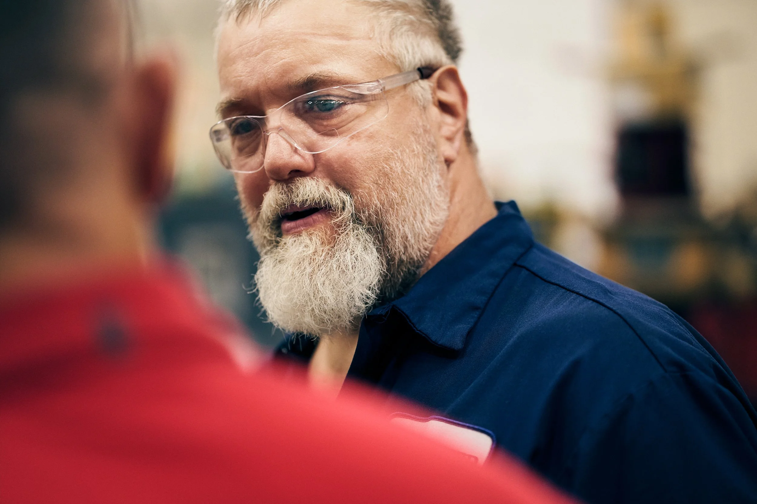 Portrait of worker in workshop environment talking to colleague
