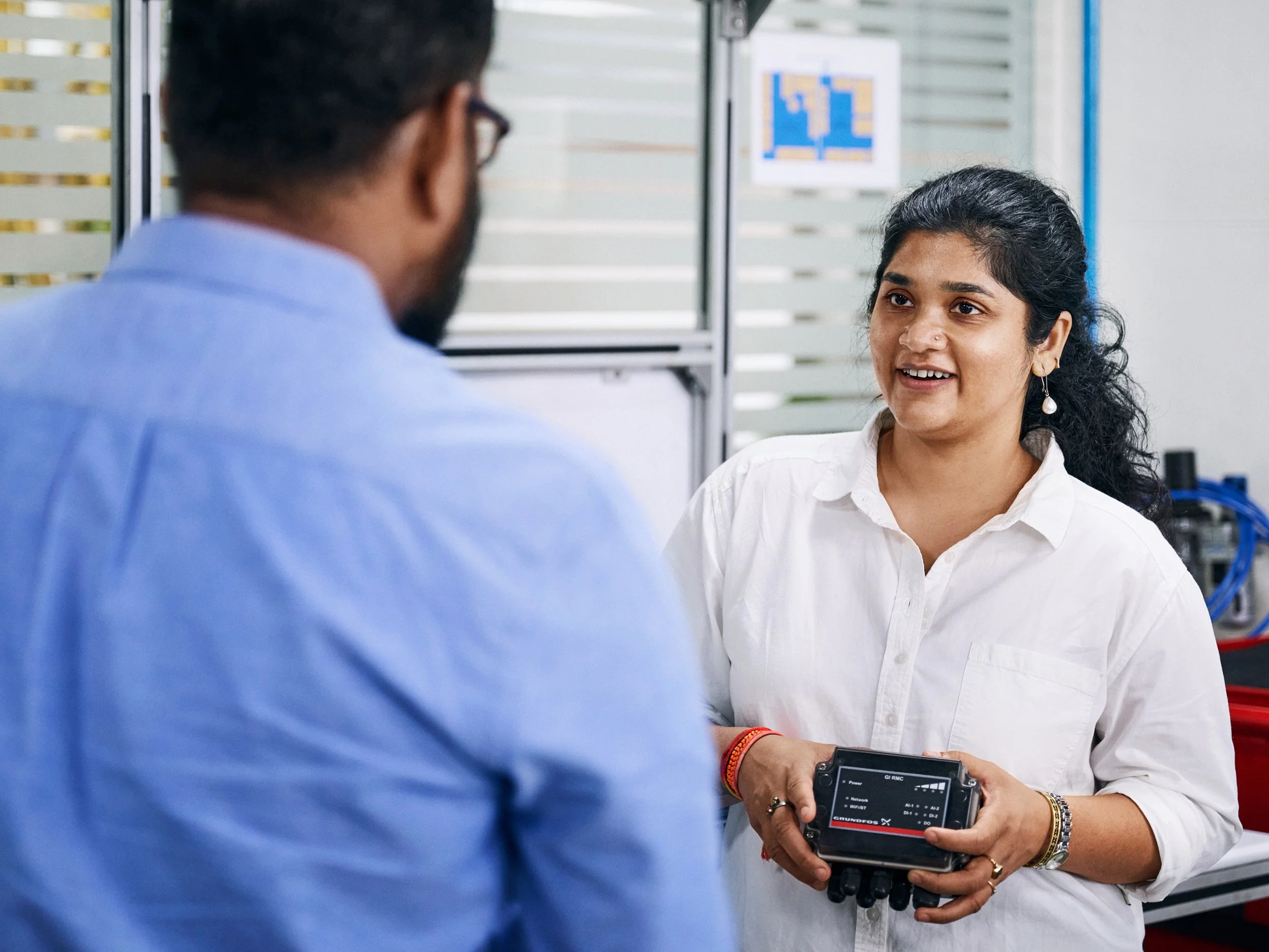 Engineer presenting digital control unit to colleague