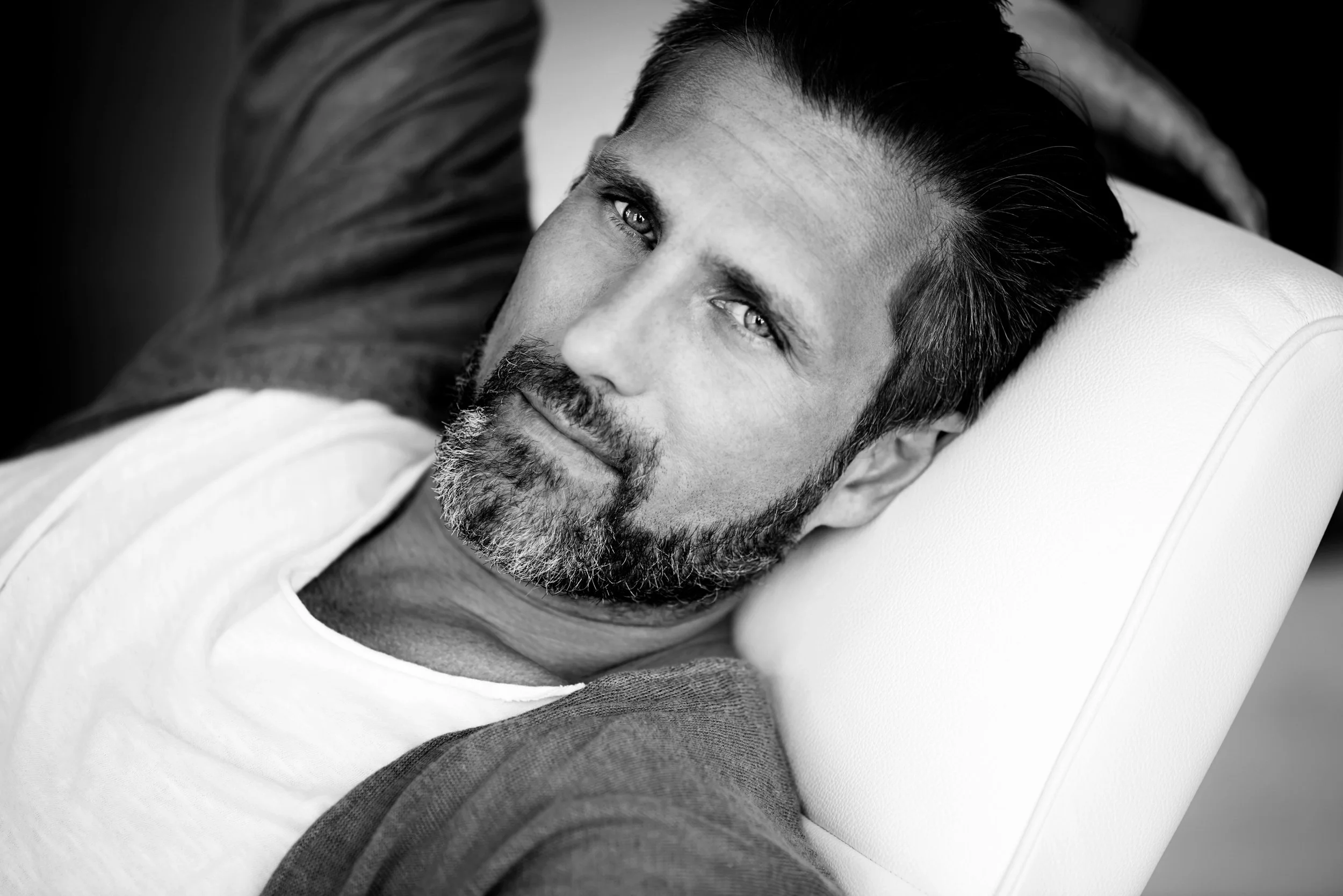 Portrait of man resting in chair, relaxed expression in black and white