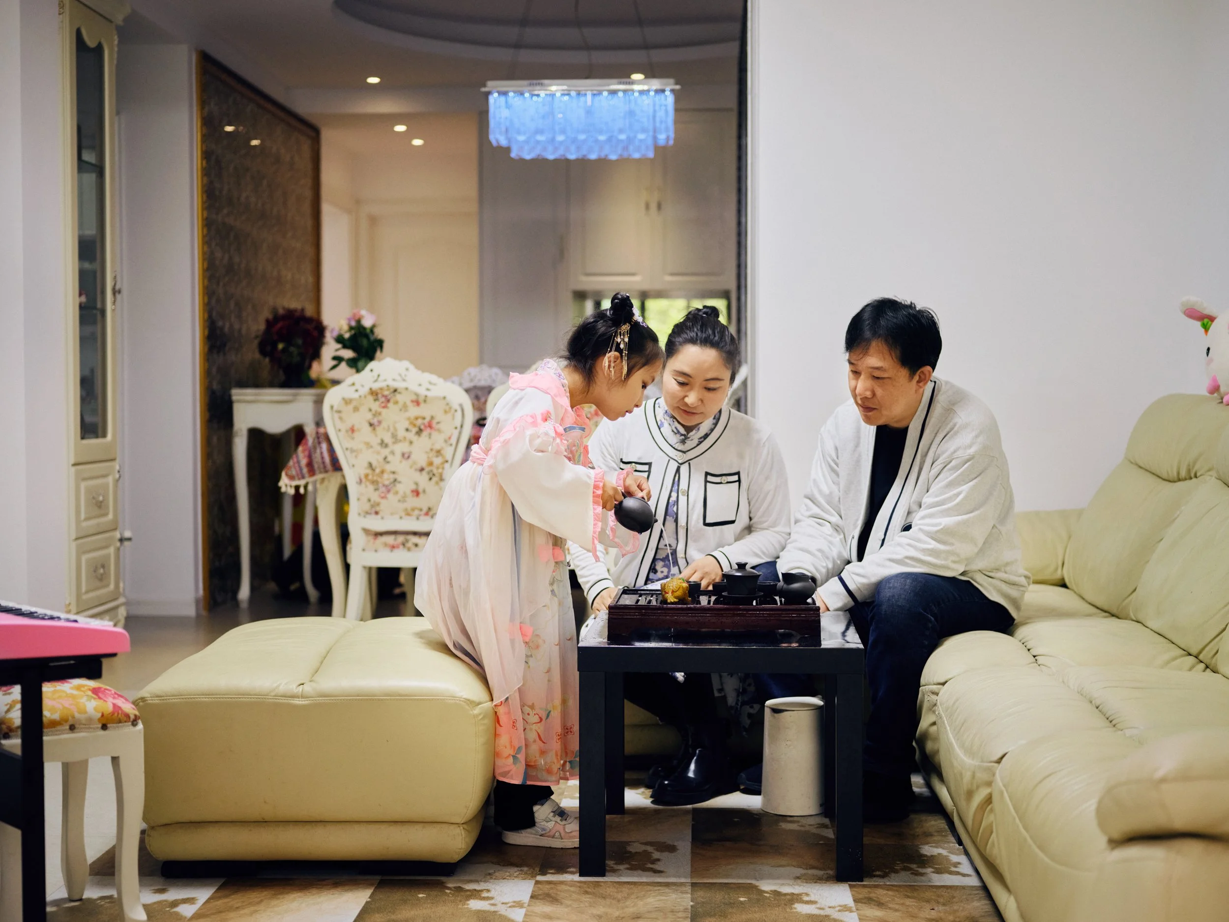 Chinese family gathered around table in living room preparing tea