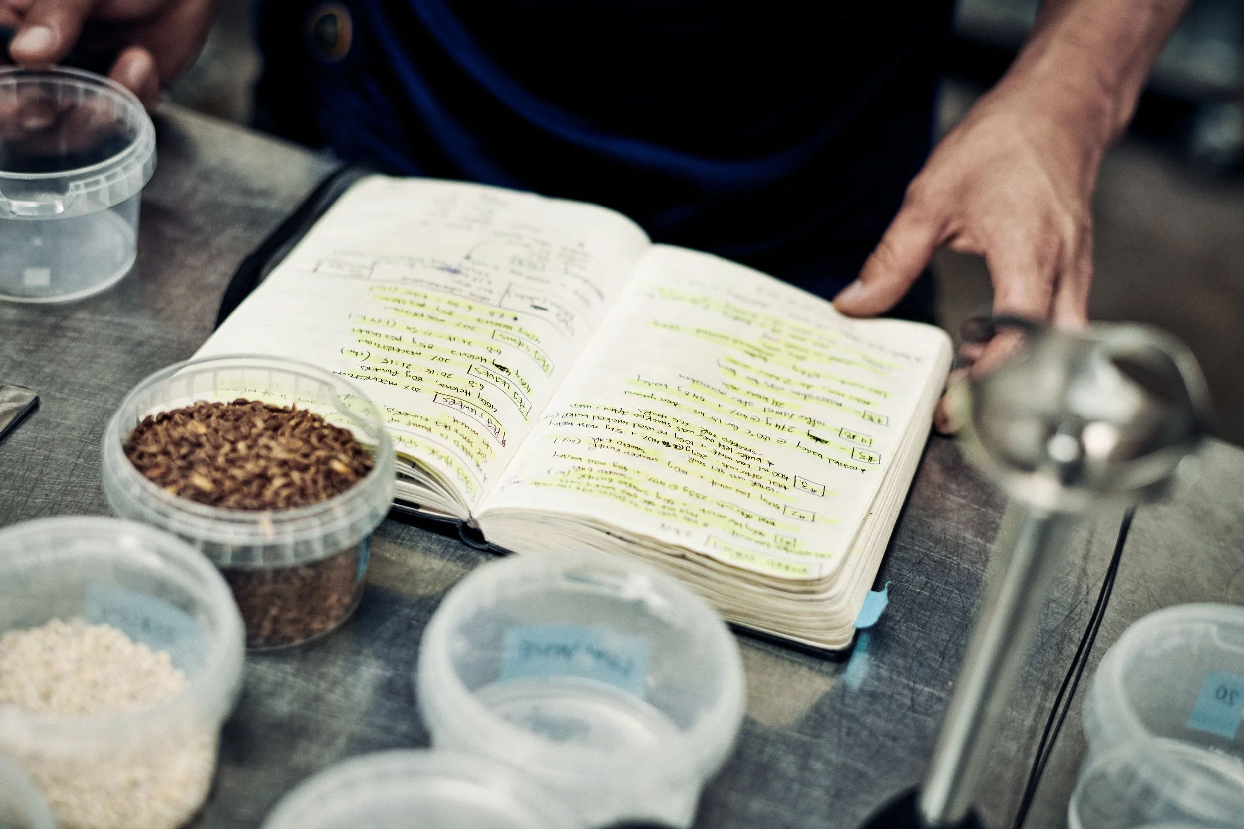 Notebook with handwritten recipes and raw ingredients, formulation and experimentation