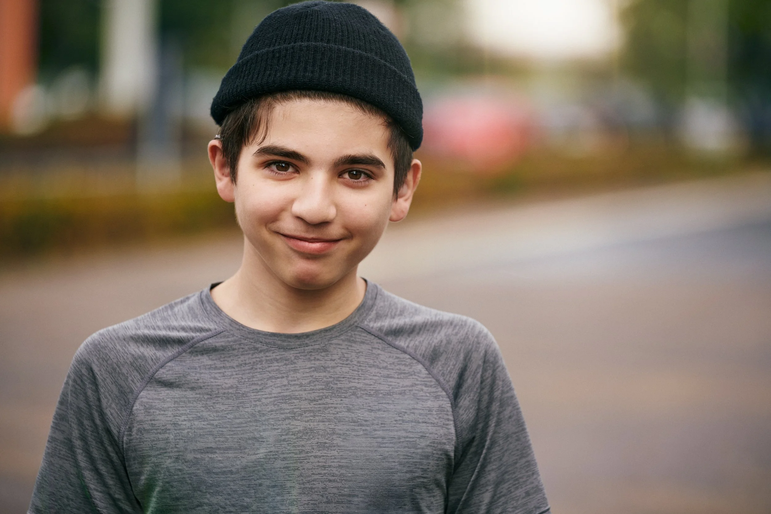 Portrait of boy wearing hearing aid outdoors, direct and confident expression