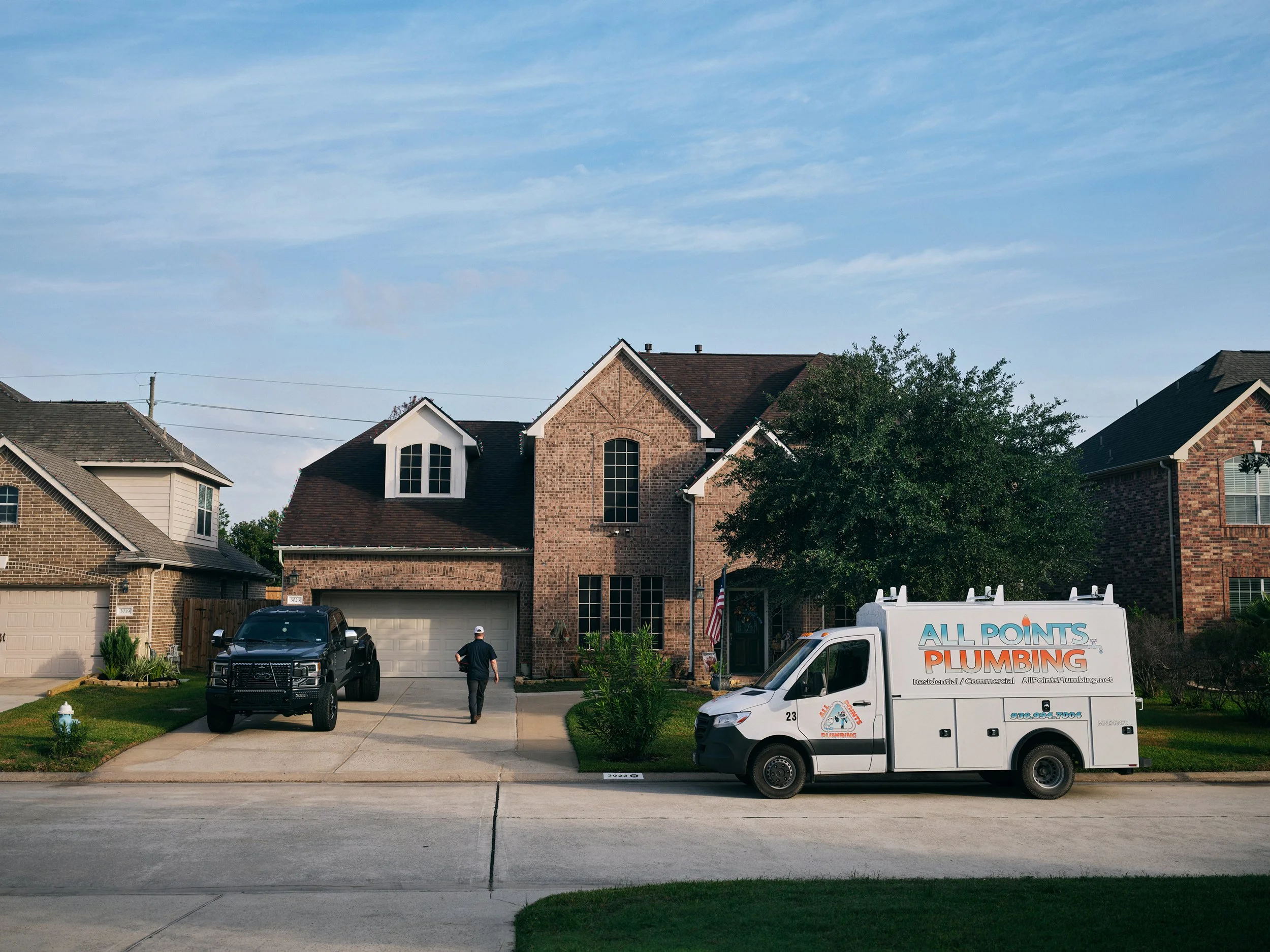 Plumbing service van parked outside suburban house