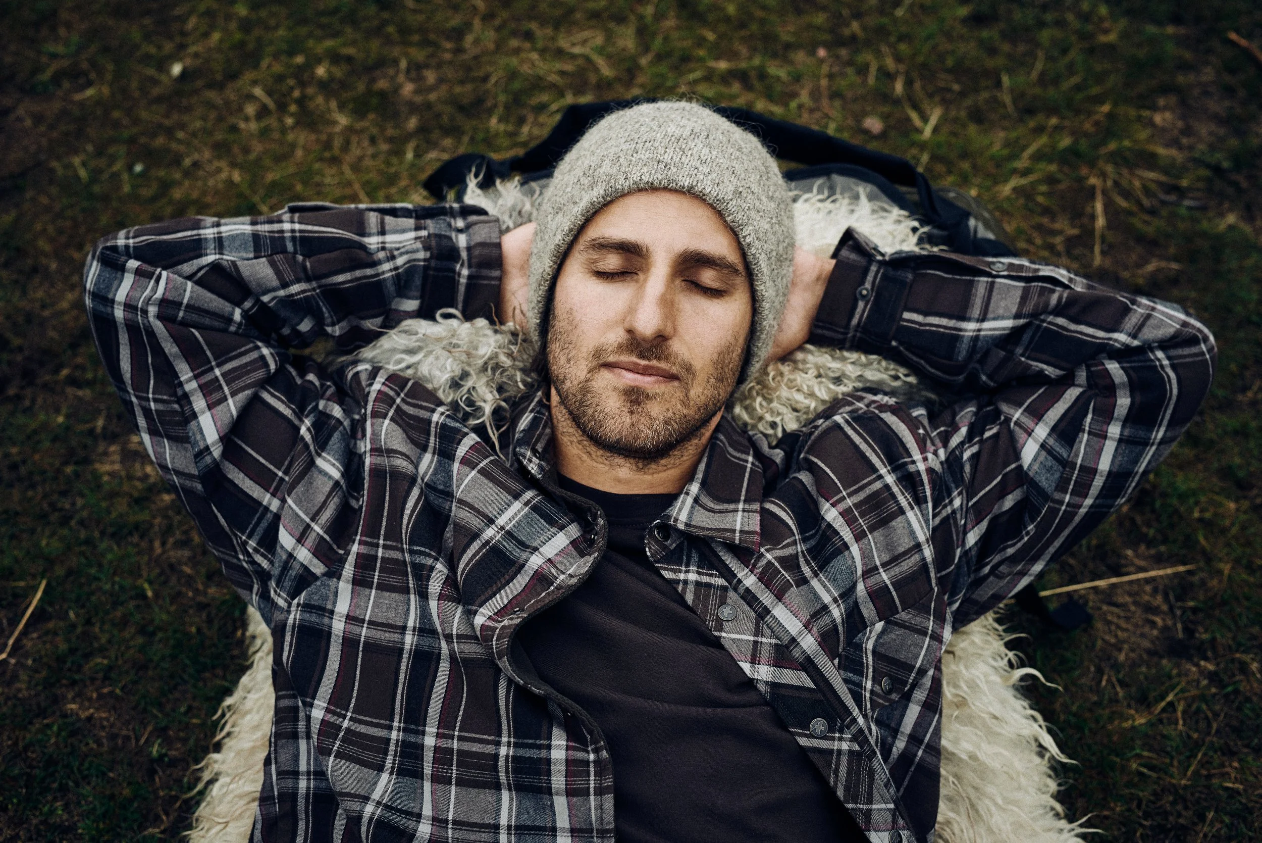 Man lying on ground with eyes closed, resting moment outdoors