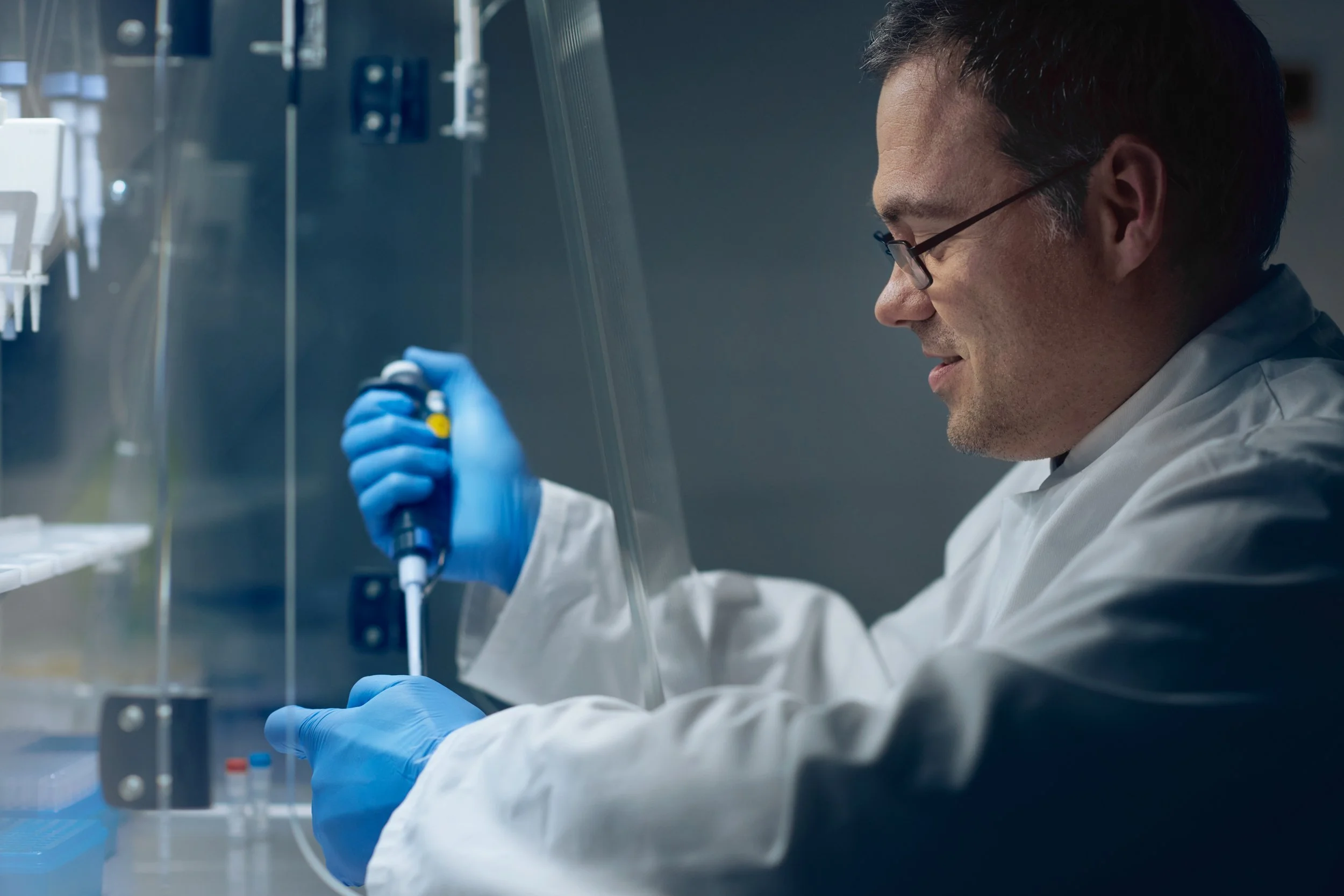 Technician performing pipetting task with precision, part of laboratory analysis workflow