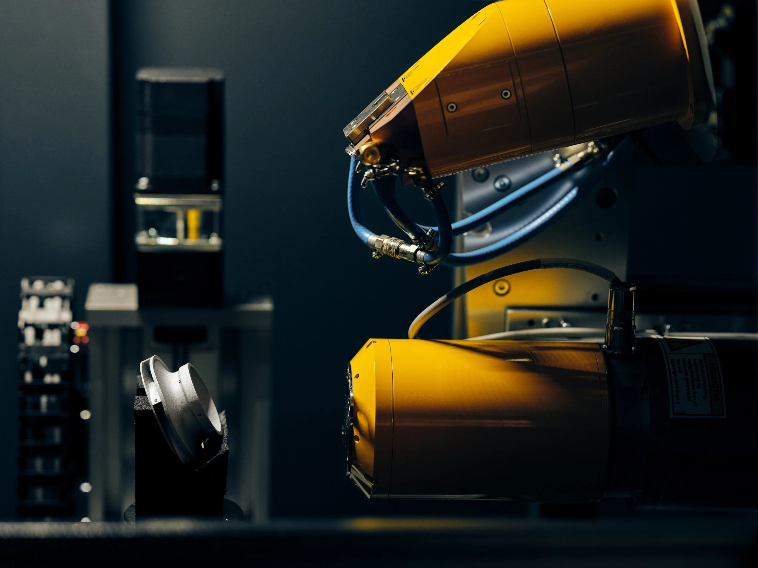 Robotic arm operating in controlled lab environment, part of automated testing setup
