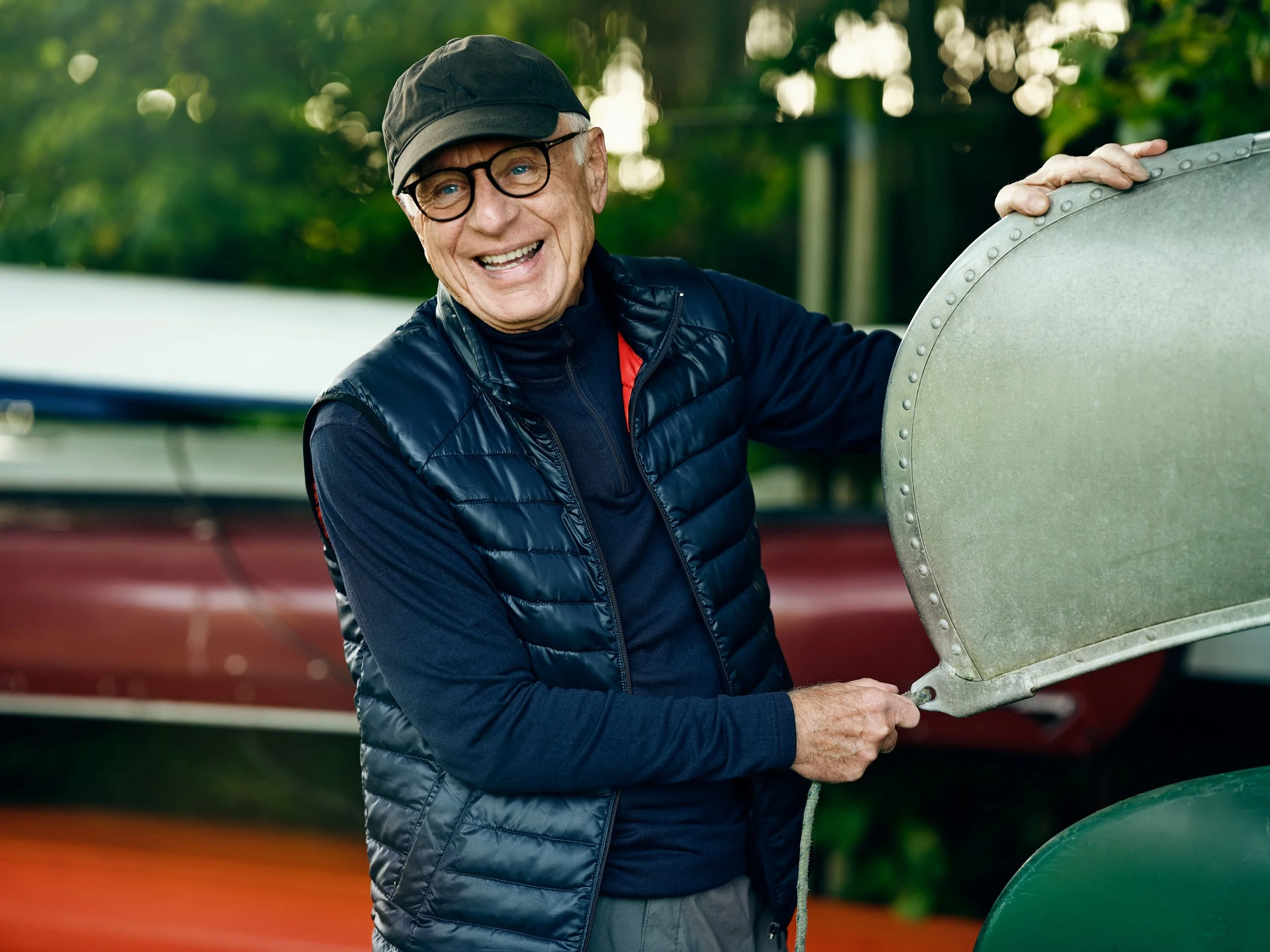 Older man lifting boat motor outdoors, physical activity in leisure setting