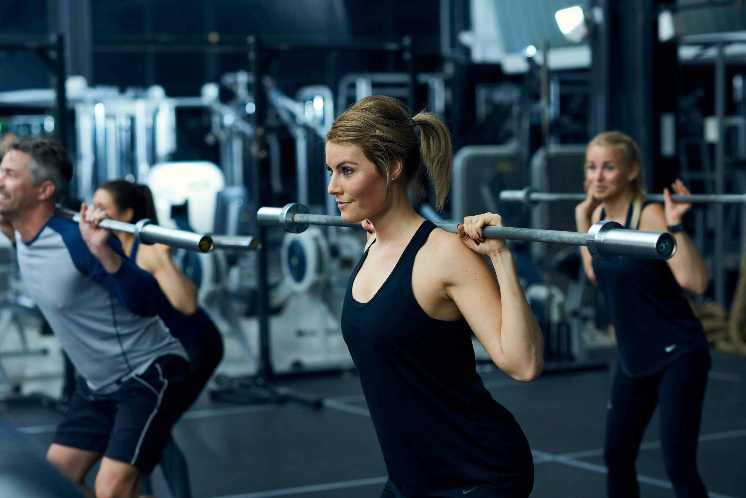 Group training with barbells in gym, strength and coordination