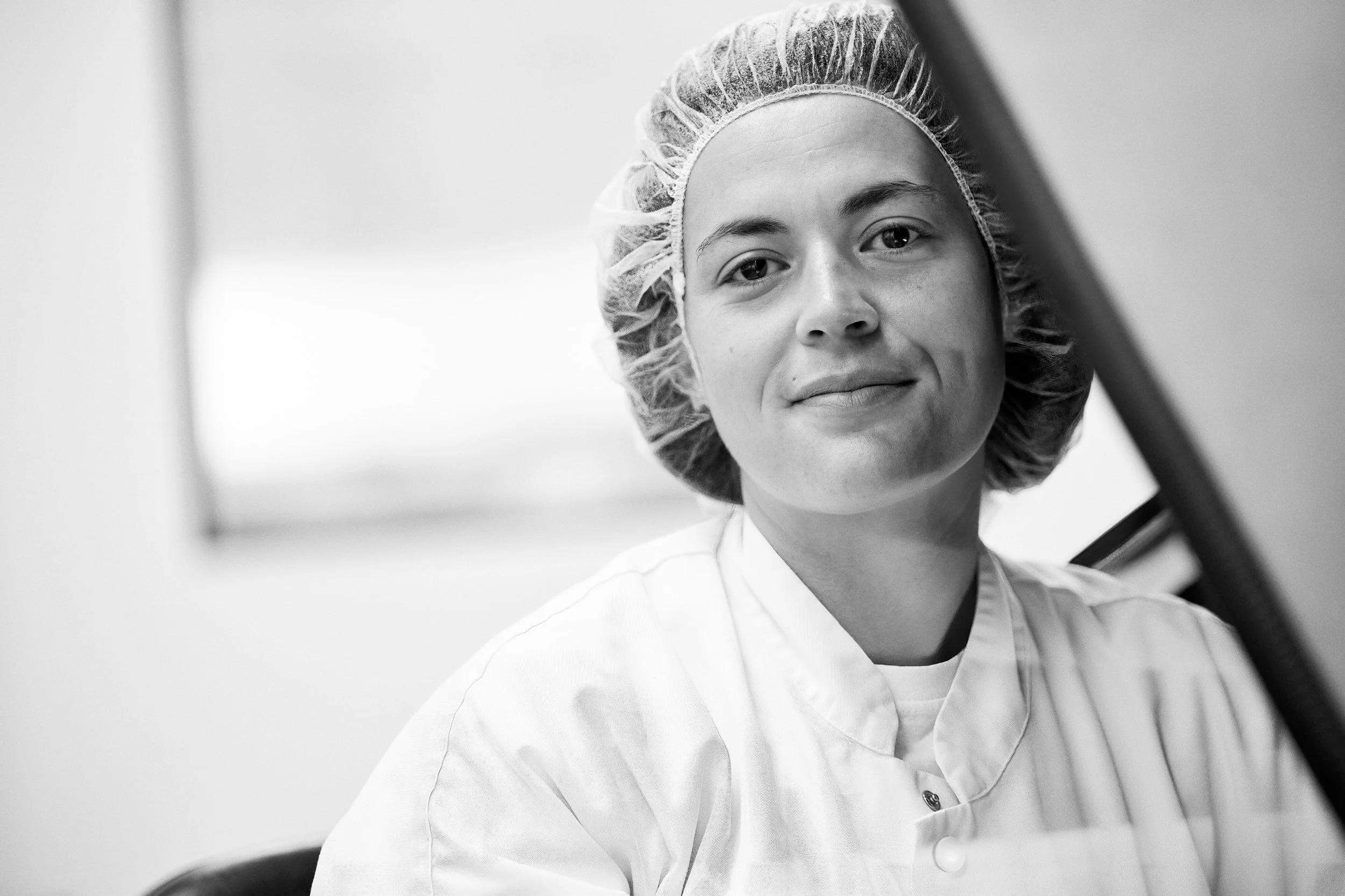 Portrait of laboratory technician in cleanroom attire, direct and neutral expression