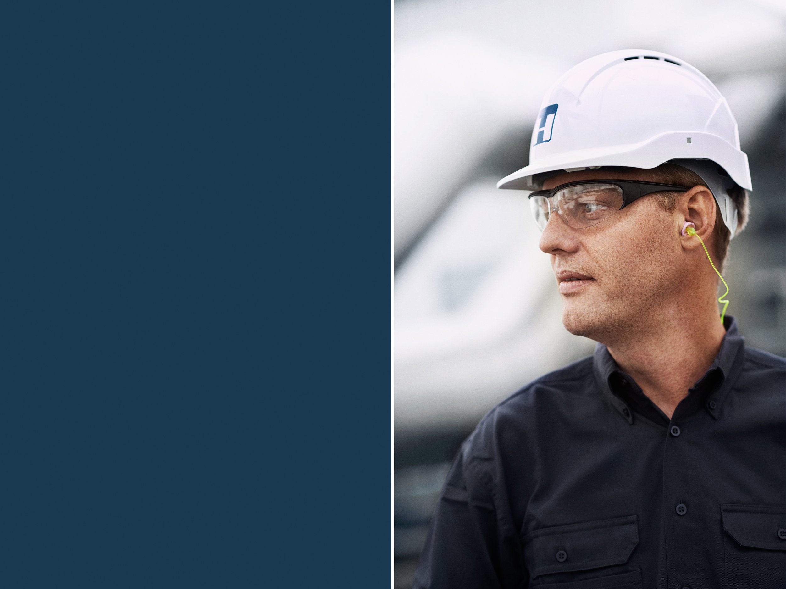 Portrait of technician wearing safety helmet and protective glasses in industrial environment