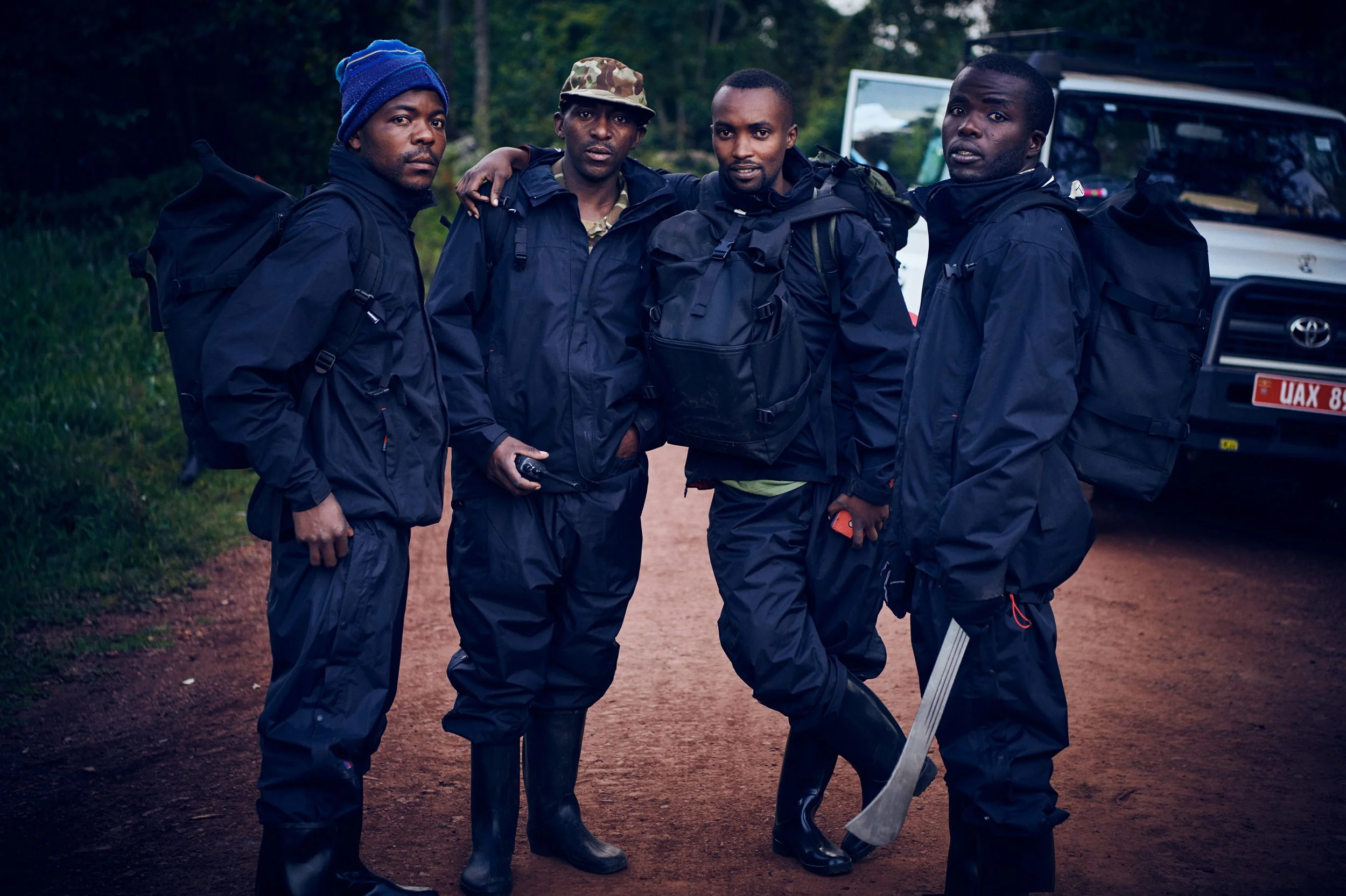 Group of field workers standing together on dirt road with equipment, ready for fieldwork
