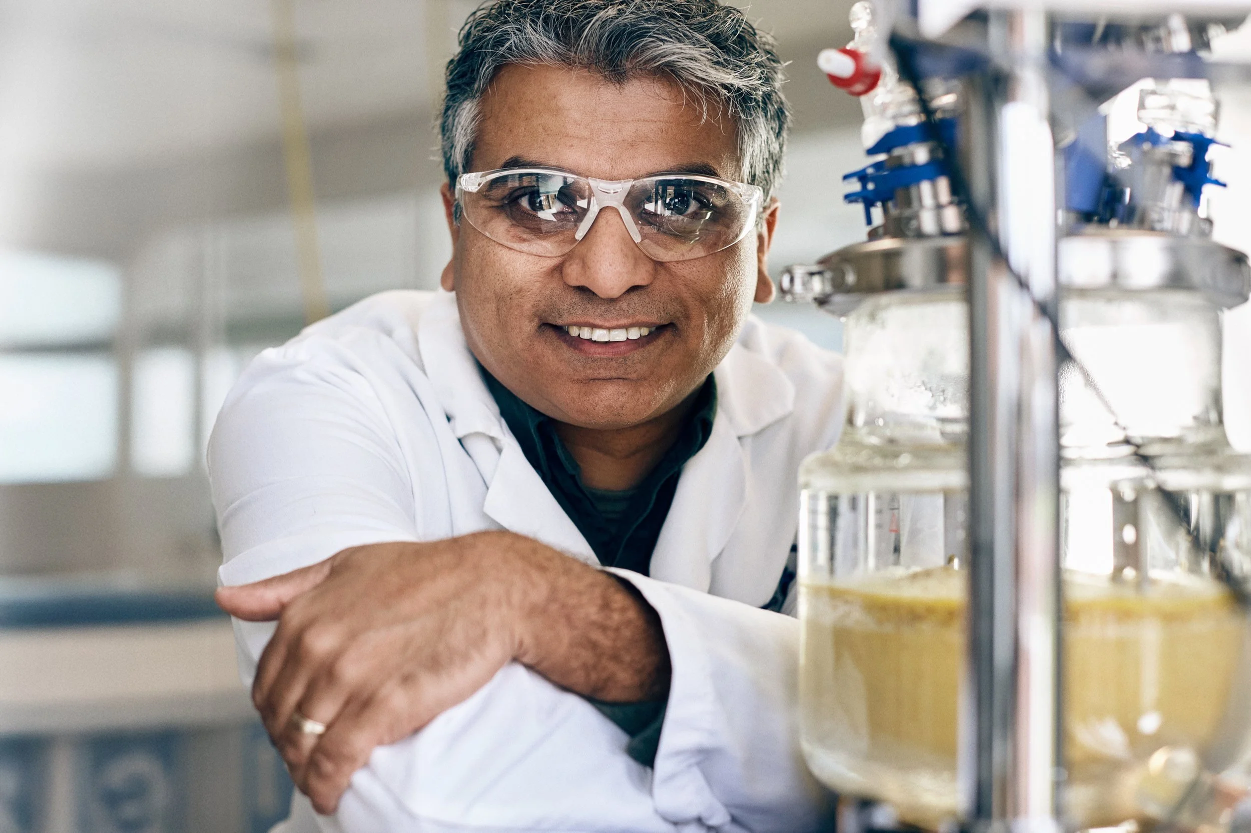Scientist working with bioreactor equipment in laboratory, biotechnology research environment
