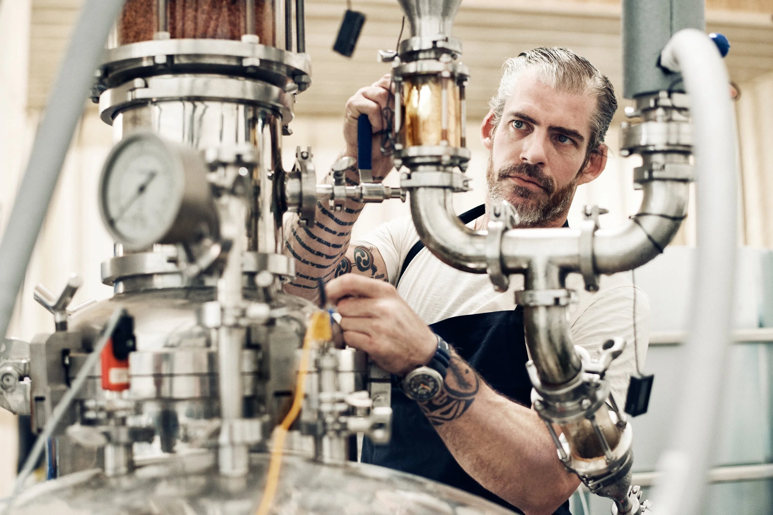 Distiller adjusting valves on stainless steel system, controlling distillation flow