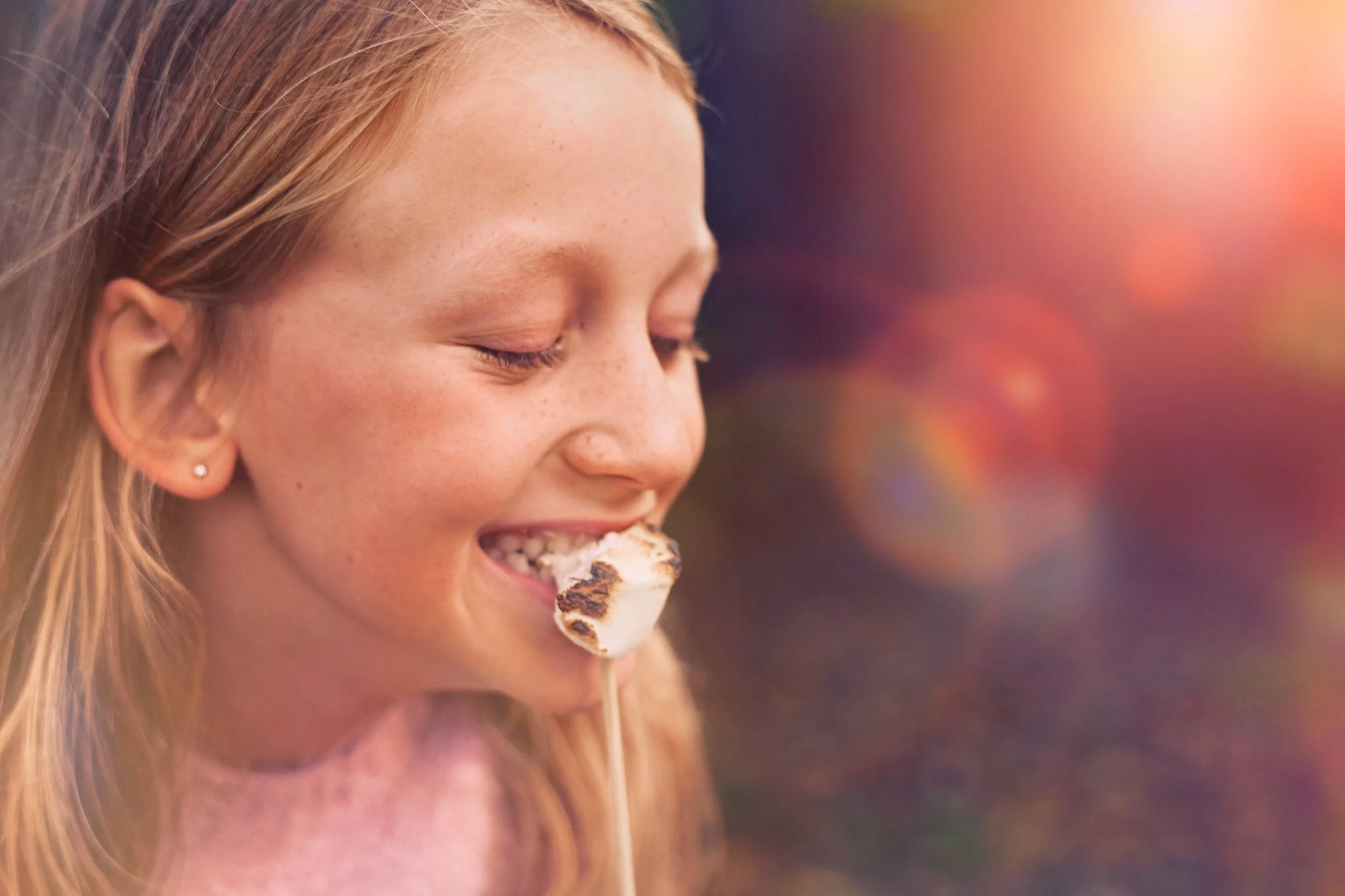Child eating roasted marshmellow, close-up of everyday moment