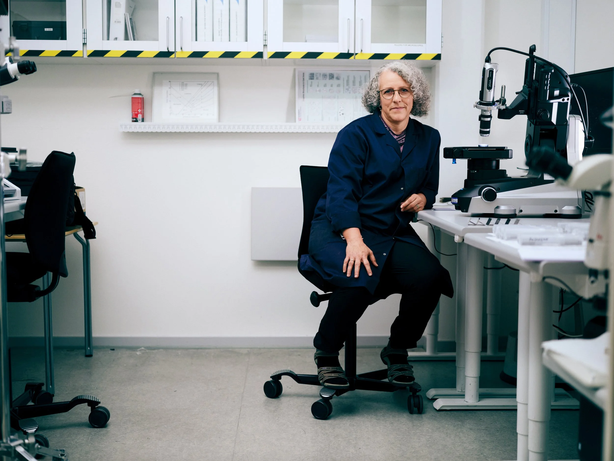 Portrait of researcher in laboratory setting, seated among testing and analysis equipment