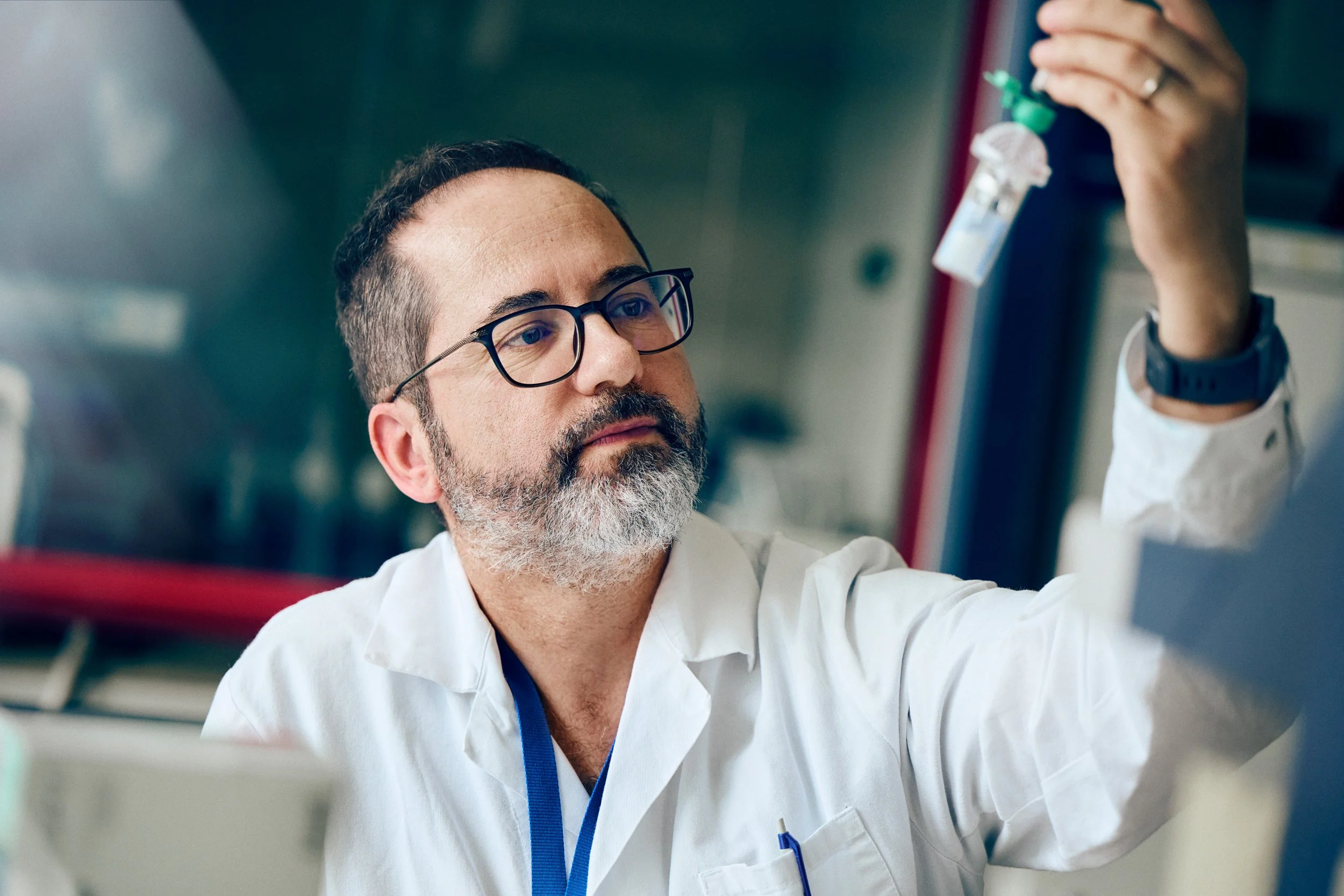 Researcher inspecting liquid sample in vial
