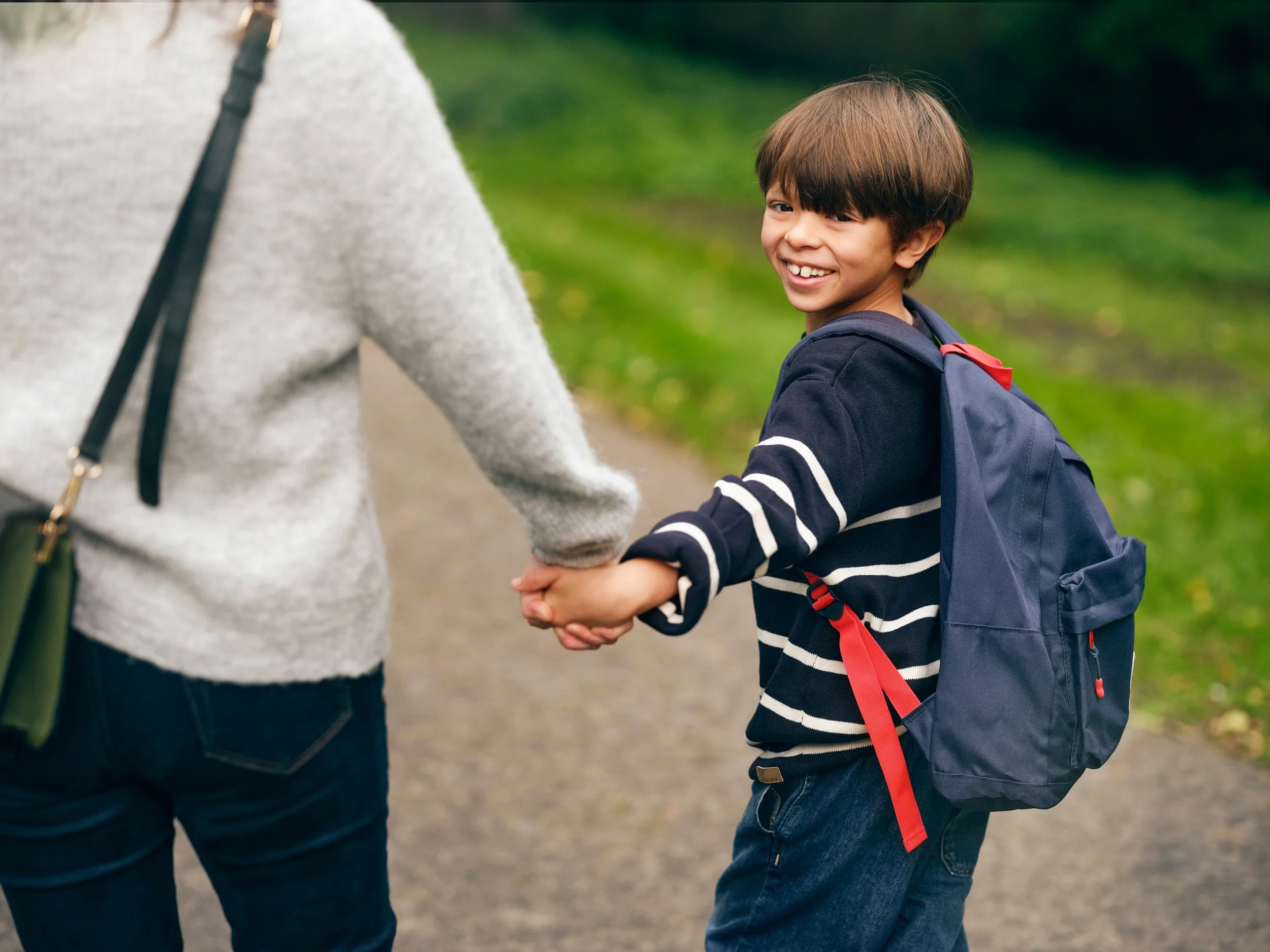 Child walking with adult while holding hands, safe everyday movement
