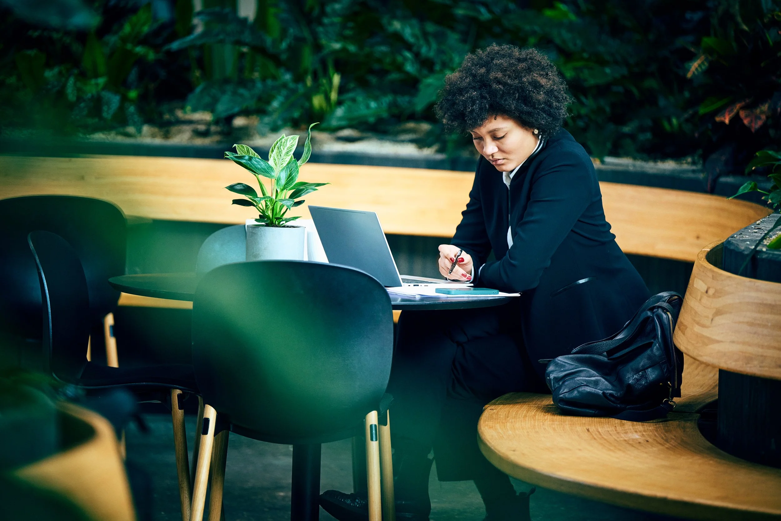 Woman working on laptop in shared indoor space, focused work moment