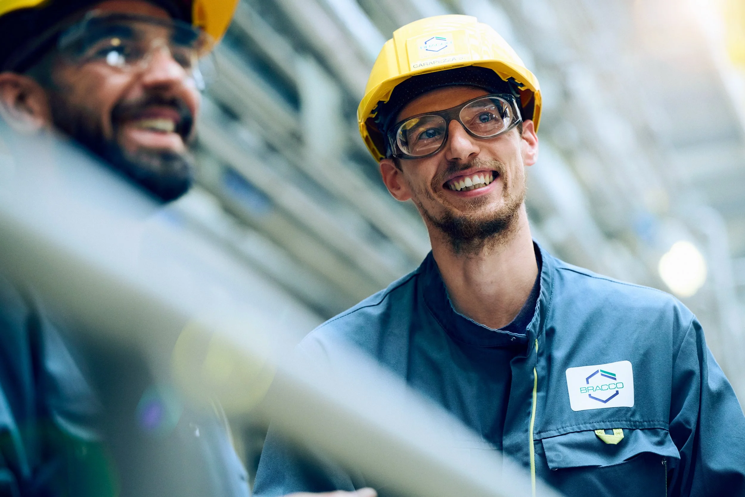 Portrait of technician in safety gear inside production environment, natural expression