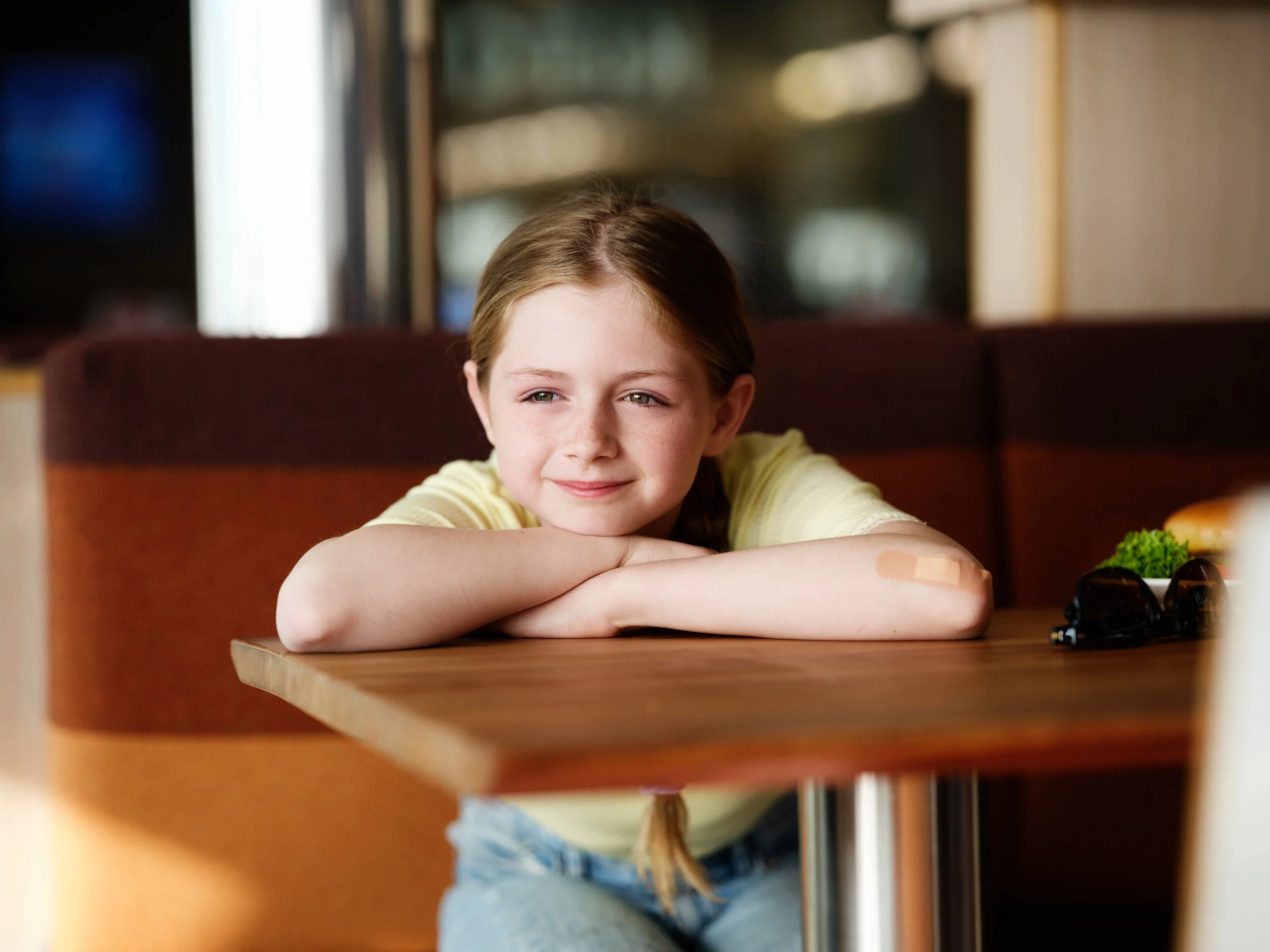 Child resting at table in ferry lounge, calm moment during journey