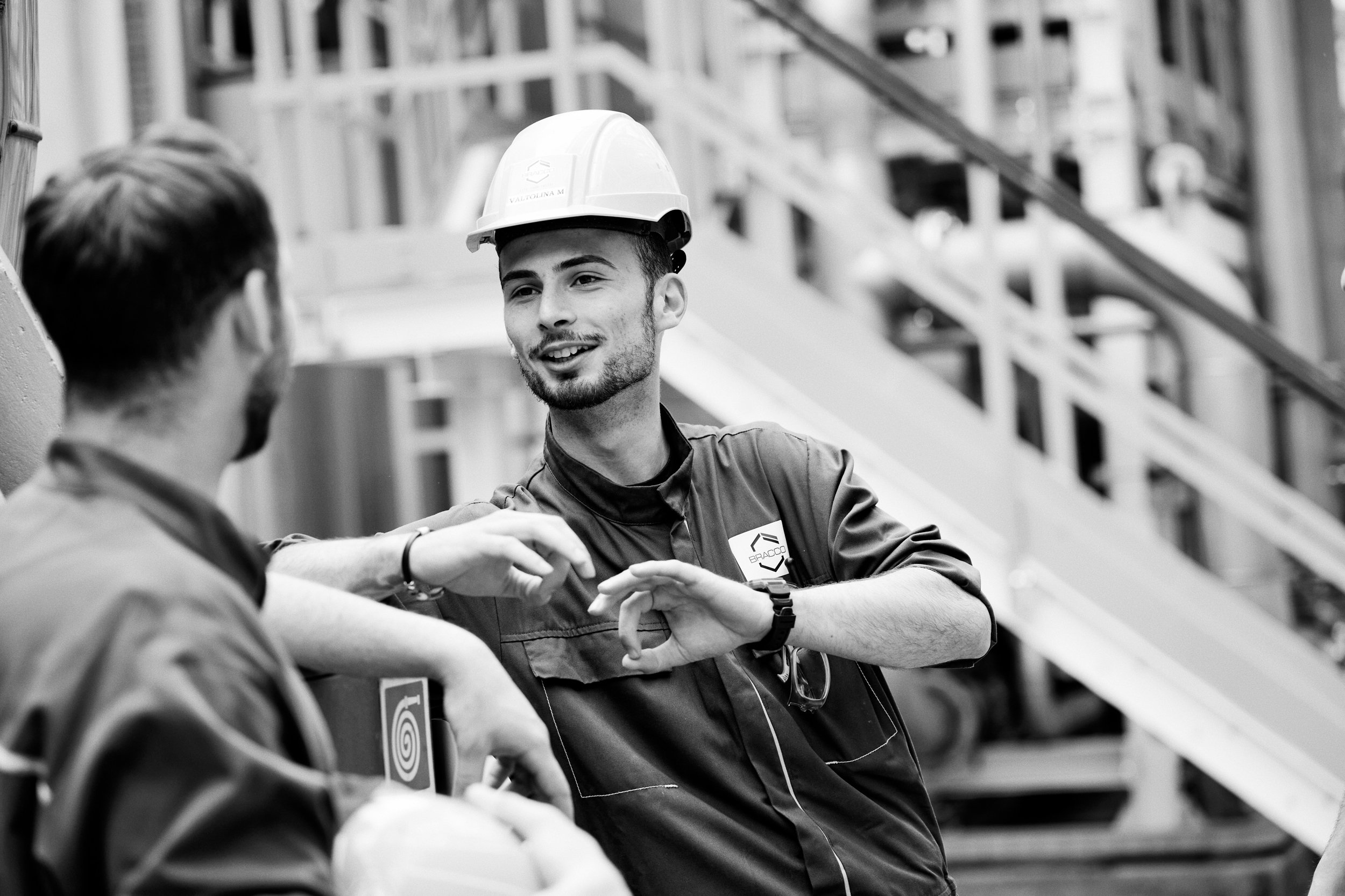 Two technicians discussing process on factory floor, active coordination during production
