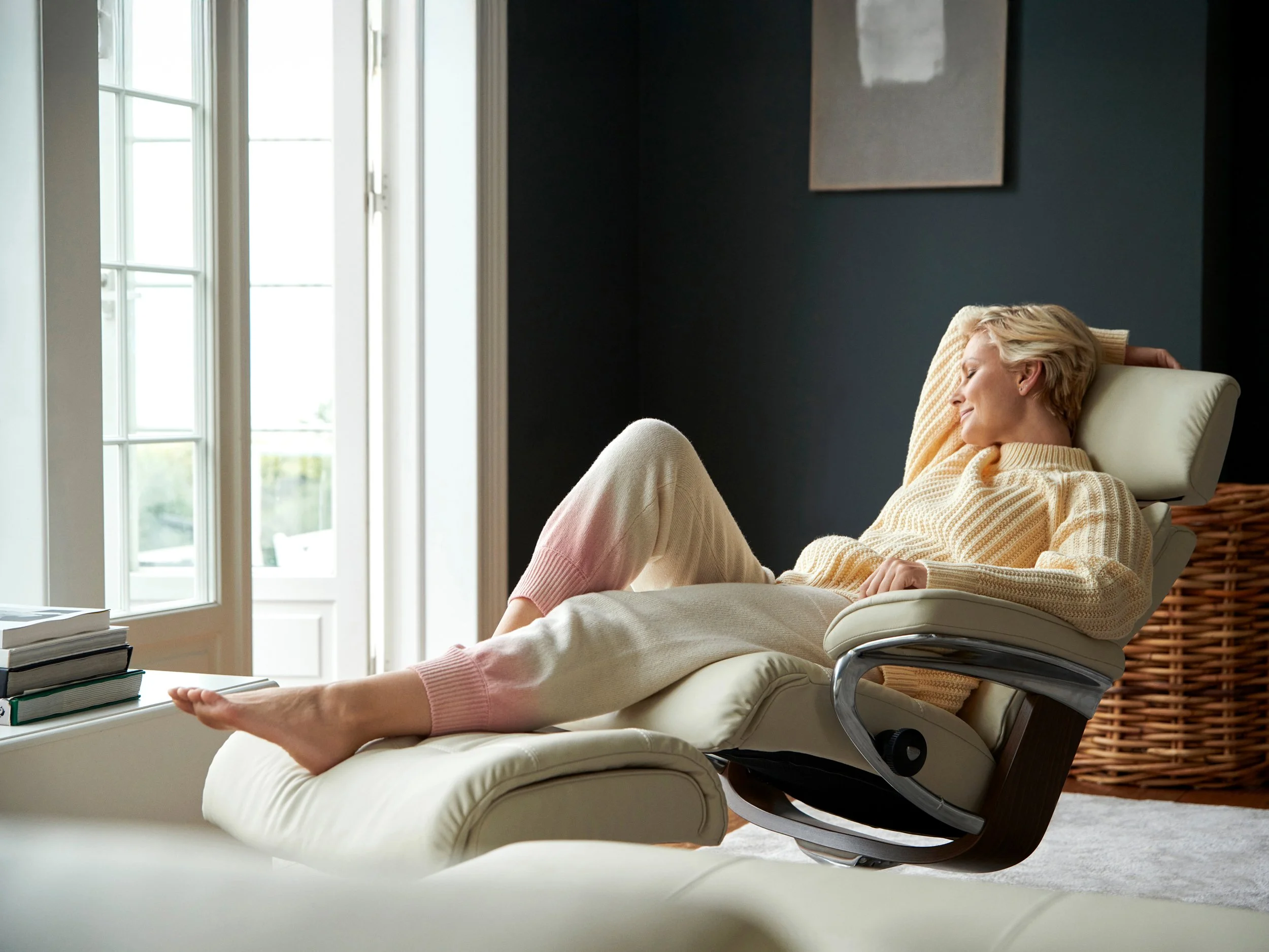 Woman reclining in chair by window, resting in soft natural daylight