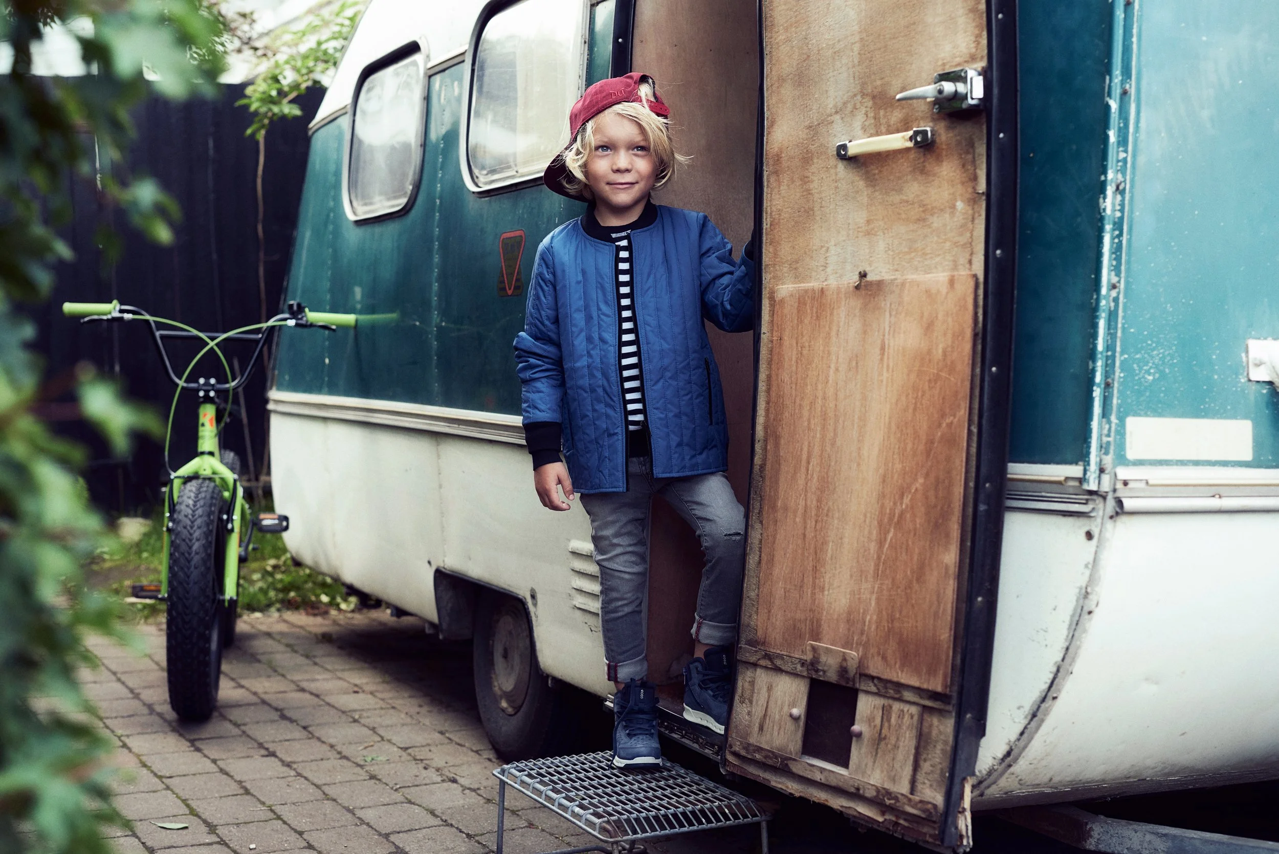 Child standing in doorway of caravan, everyday outdoor moment