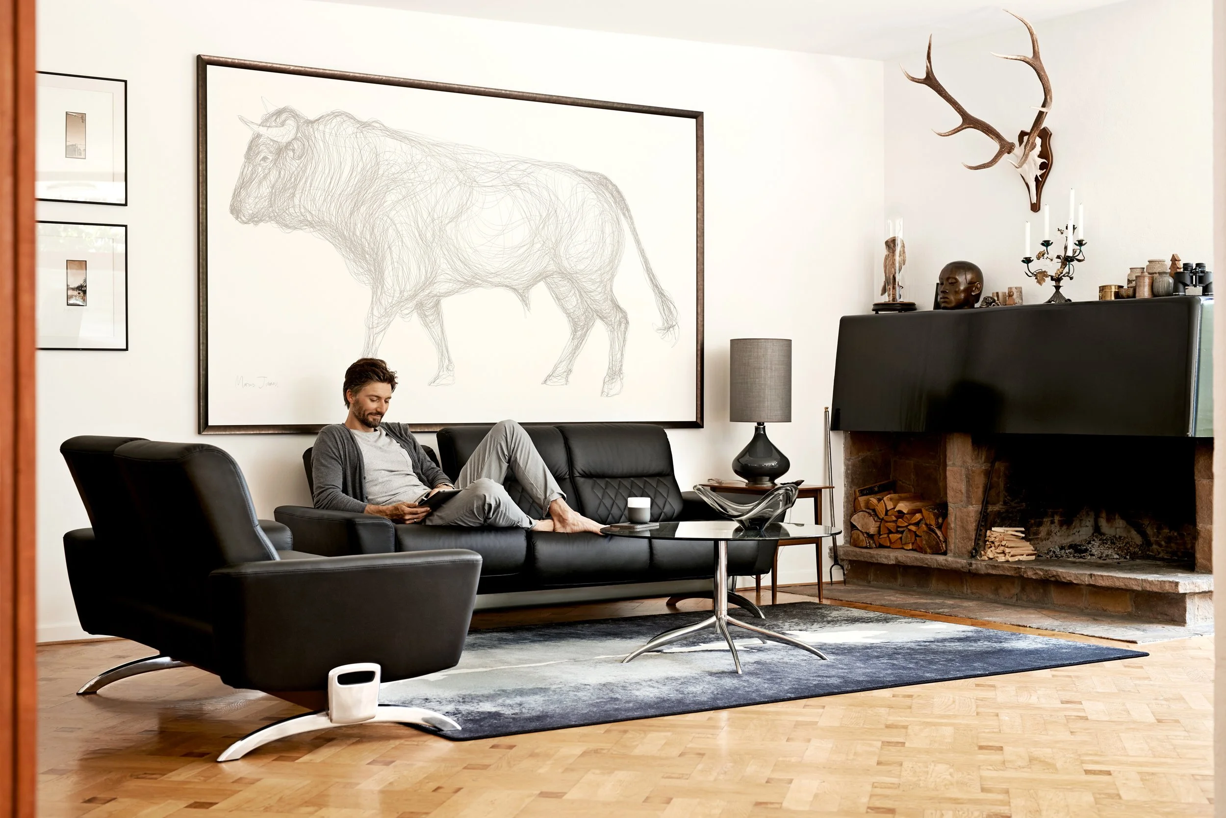 Man sitting on sofa in living room with fireplace, calm domestic setting